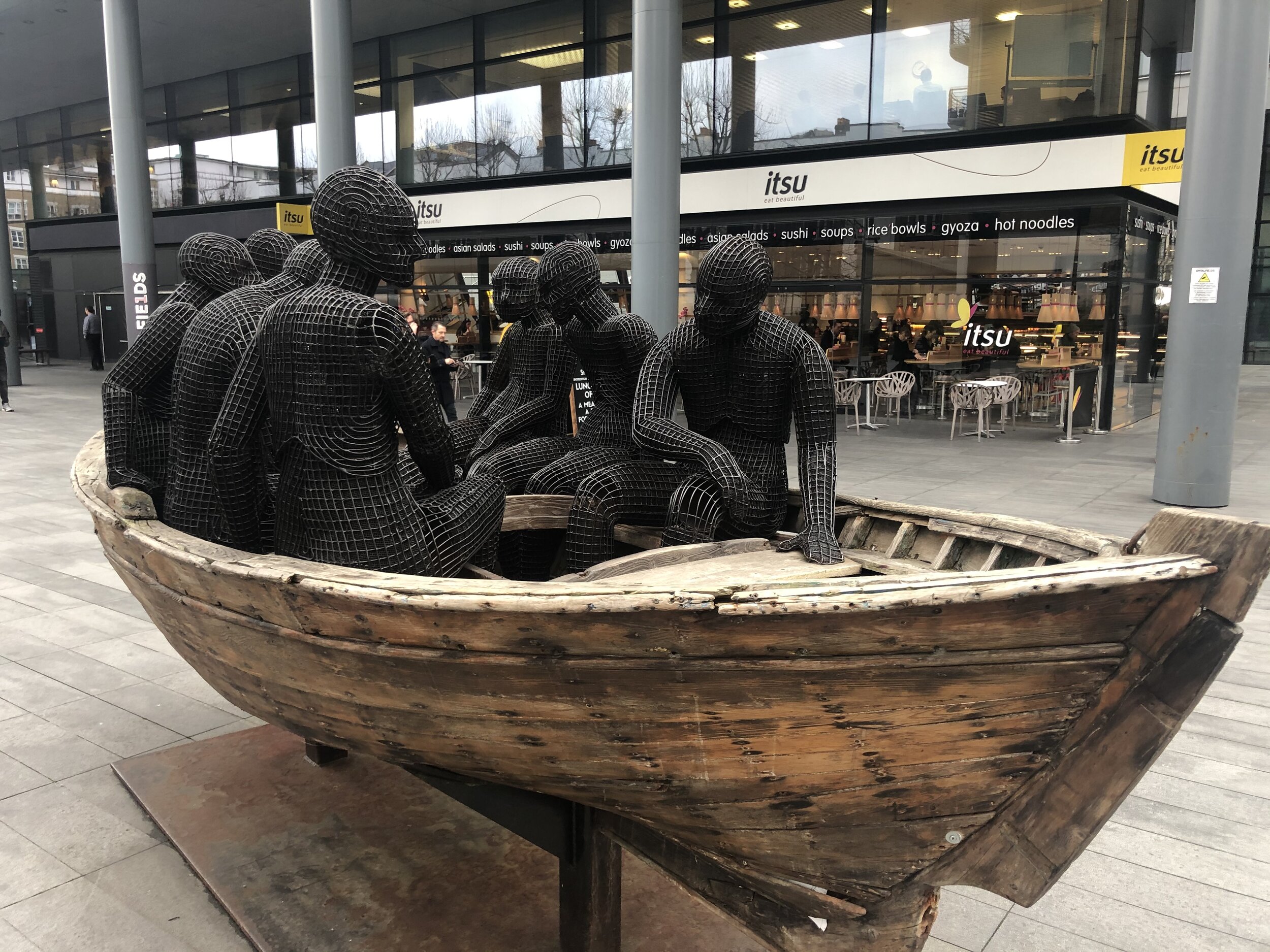 "Wooden Boat With Seven People", Bishops Square