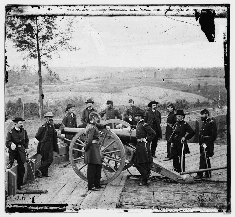Gen. William T. Sherman, leaning on breach of gun, with staff at Federal Fort No. 7 in Atlanta, 1864. Courtesy of the Library of Congress.