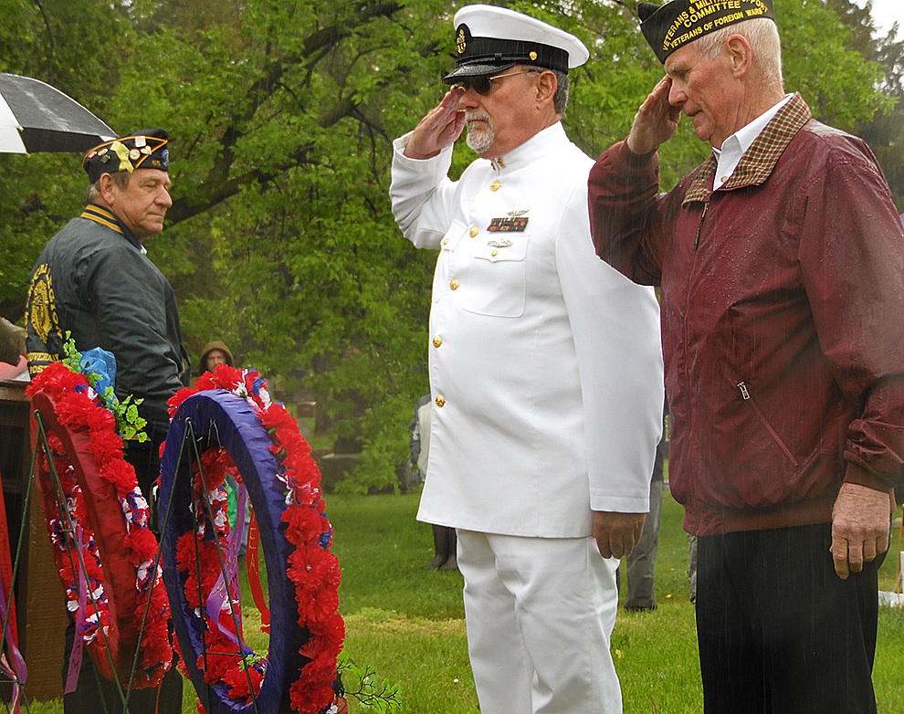 Michael Knowlton saluting after placing the ribbon to remember those who died in service in Panama. Joining in the salute is Mike Webster. (Rachel Hunter photo)