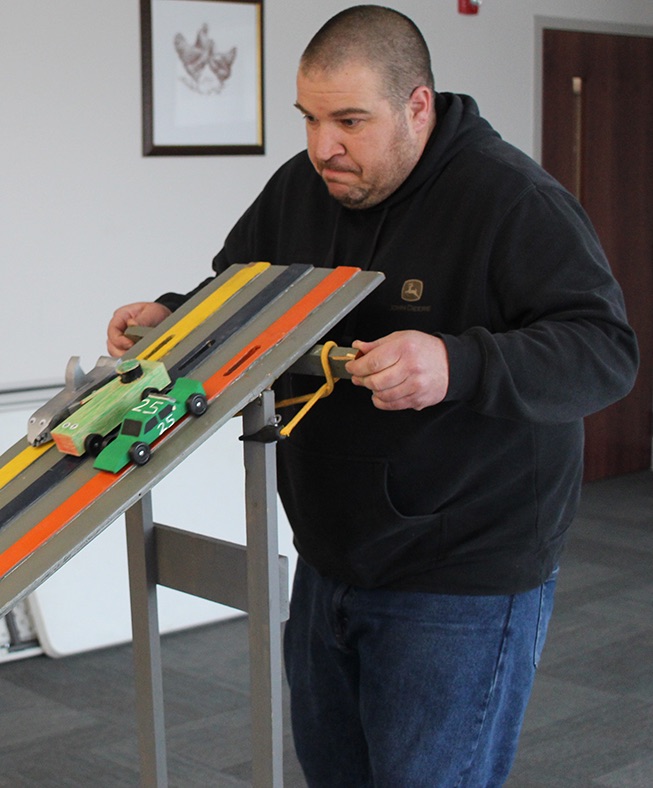   Gary Gilbo of Richville at the starting line as he released the pinewood derby cars down the track. (Rachel Hunter photo)  