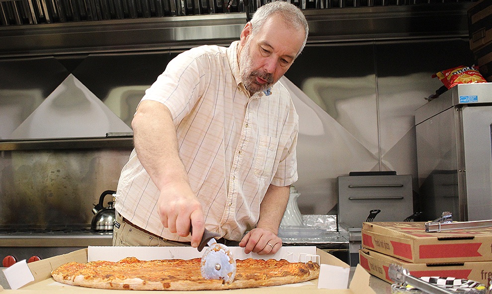   David Spilman, Jr. of Gouverneur cuts pizza slices for those attending the first-ever Gouverneur Cub Scout Pack 2035 Pinewood Derby on Saturday, March 30 at the Gouverneur Community Center in the Kinney Drugs Foundation Kitchen area. (Rachel Hunter