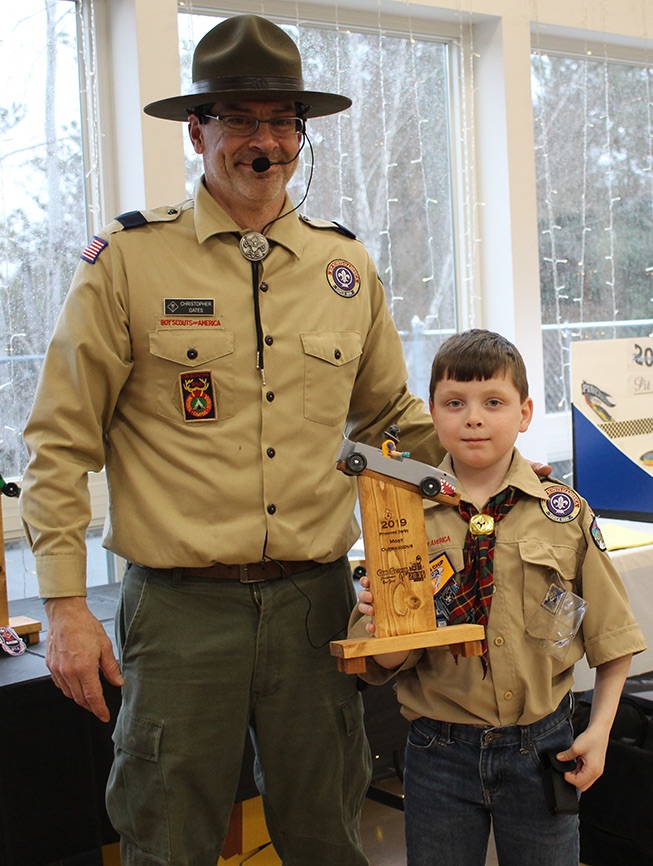   Mitchell Romans won the Most Outrageous trophy for his shark-themed pinewood derby car. Mitchell Romans is pictured (at right) with Cubmaster Chris Gates (at left). (Rachel Hunter photo)  