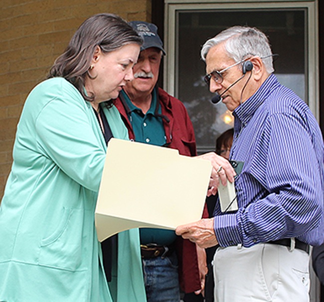   Shari Barnhart of Rainbow Tech Designs (Gouverneur Museum webmaster) fits Gouverneur Historian Joe Laurenza with a microphone so that all could clearly hear the information presented during the historic walking tour on Saturday, August 24. The pict