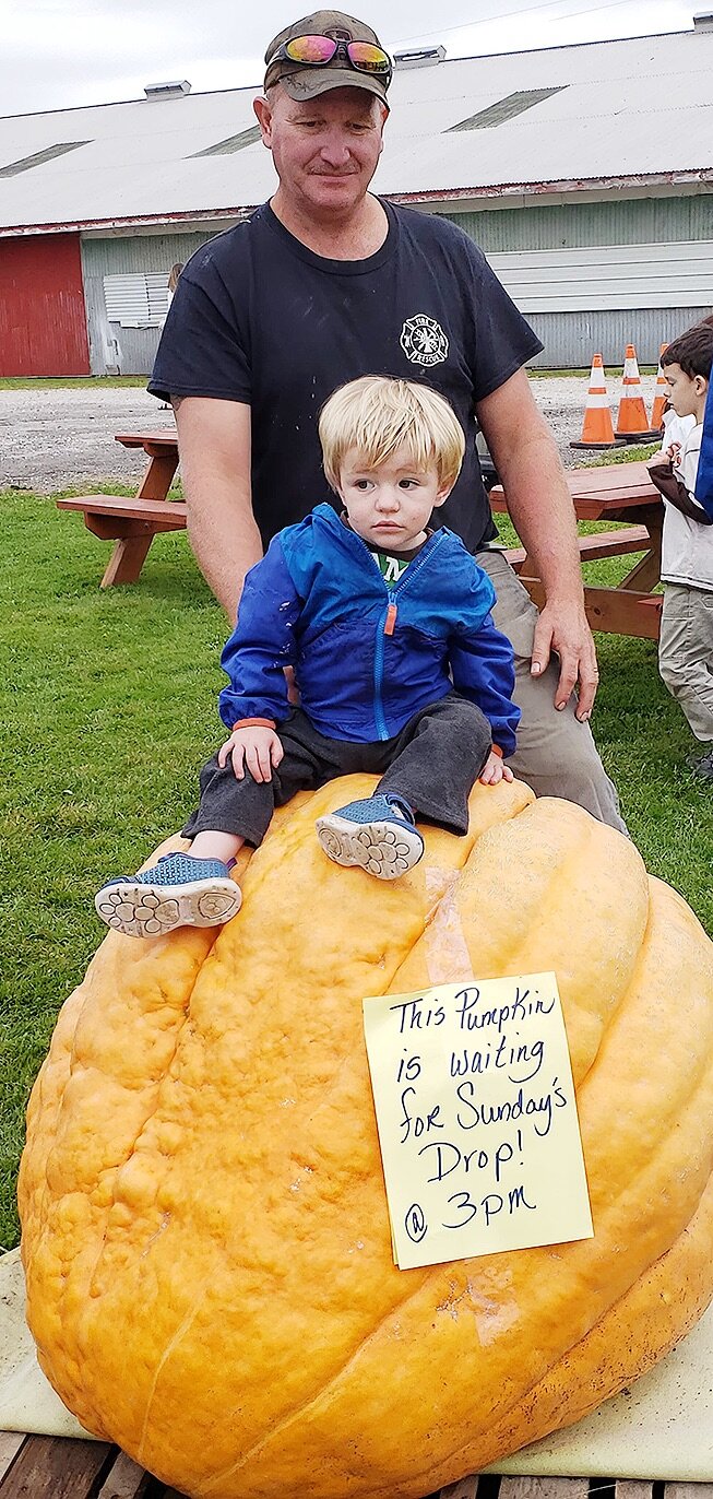   DeKalb Junction Fire Chief Bob Drake enjoying the 2019 Gouverneur Pumpkin Festival on Saturday, September 28 with his grandson, Robert, at the Gouverneur Fairgrounds. Robert is pictured sitting on the giant pumpkin that was dropped on Sunday, Septe