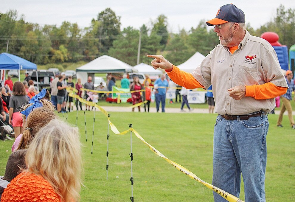   Gouverneur Chamber Director Gale Ferguson encouraging festival-goers to be prepared to duck in case of flying pumpkin meat just before the first 2019 Gouverneur Pumpkin Festival Giant Pumpkin Drop. (Rachel Hunter photo)  