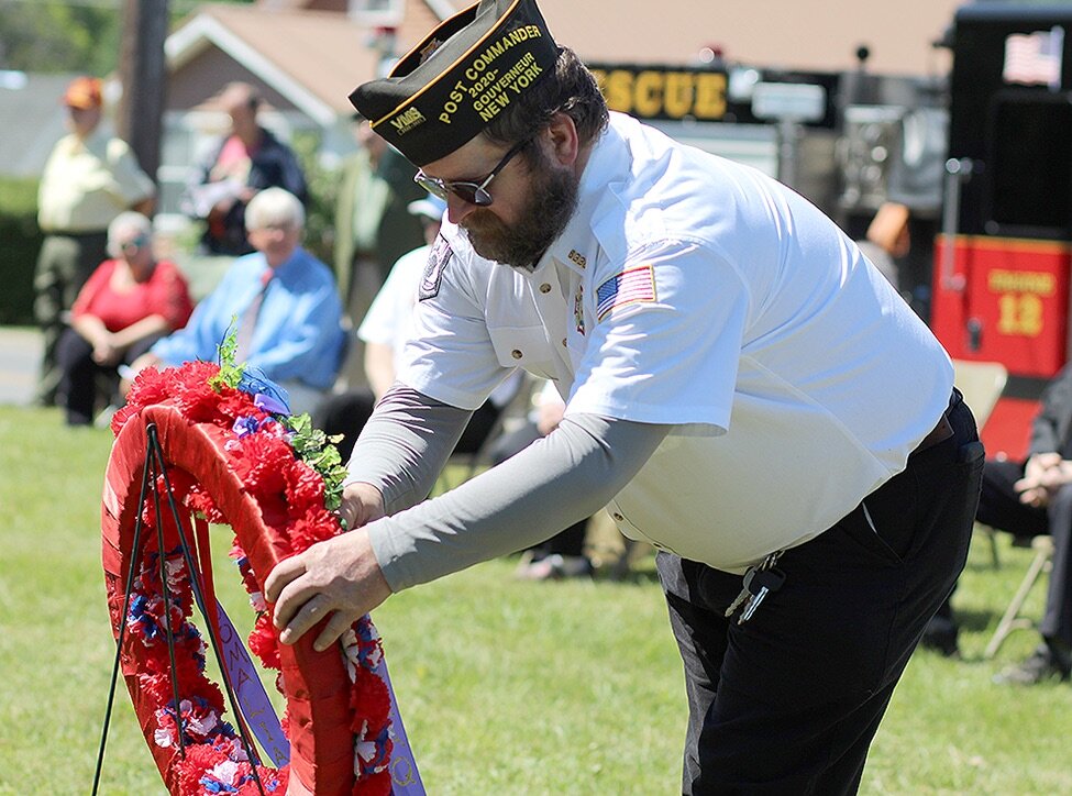    Silas Wainwright VFW Post No. 6338 Commander John Holt placing a ribbon on the ceremonial wreath during the Gouverneur Memorial Day observance. (Rachel Hunter photo)  