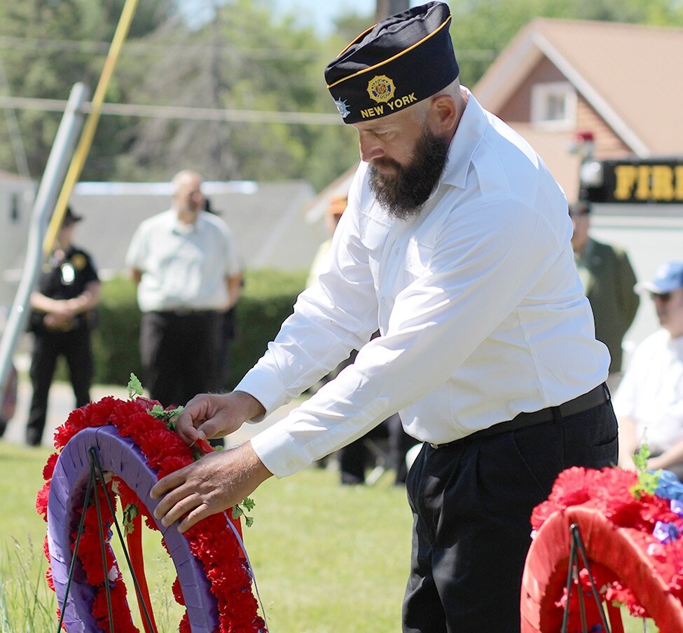    James Maloy American Legion Post No. 65 Commander Jason Carvel placing a ribbon on the ceremonial wreath. (Rachel Hunter photo)  