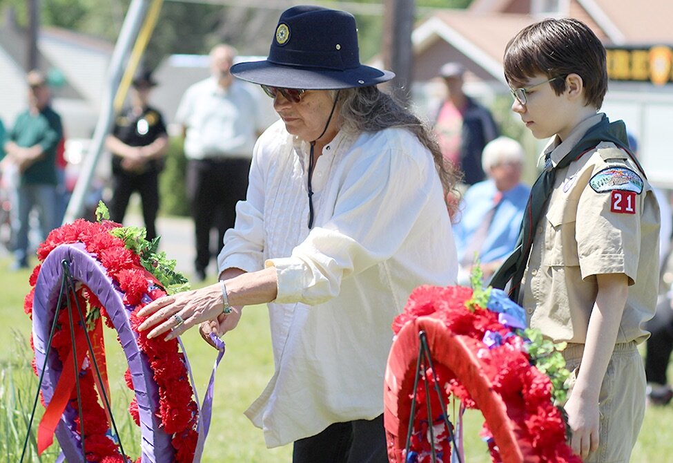    Deanna Cline placing the James Maloy Post No. 65 American Legion Ladies Auxiliary ribbon on the ceremonial wreath. (Rachel Hunter photo)  
