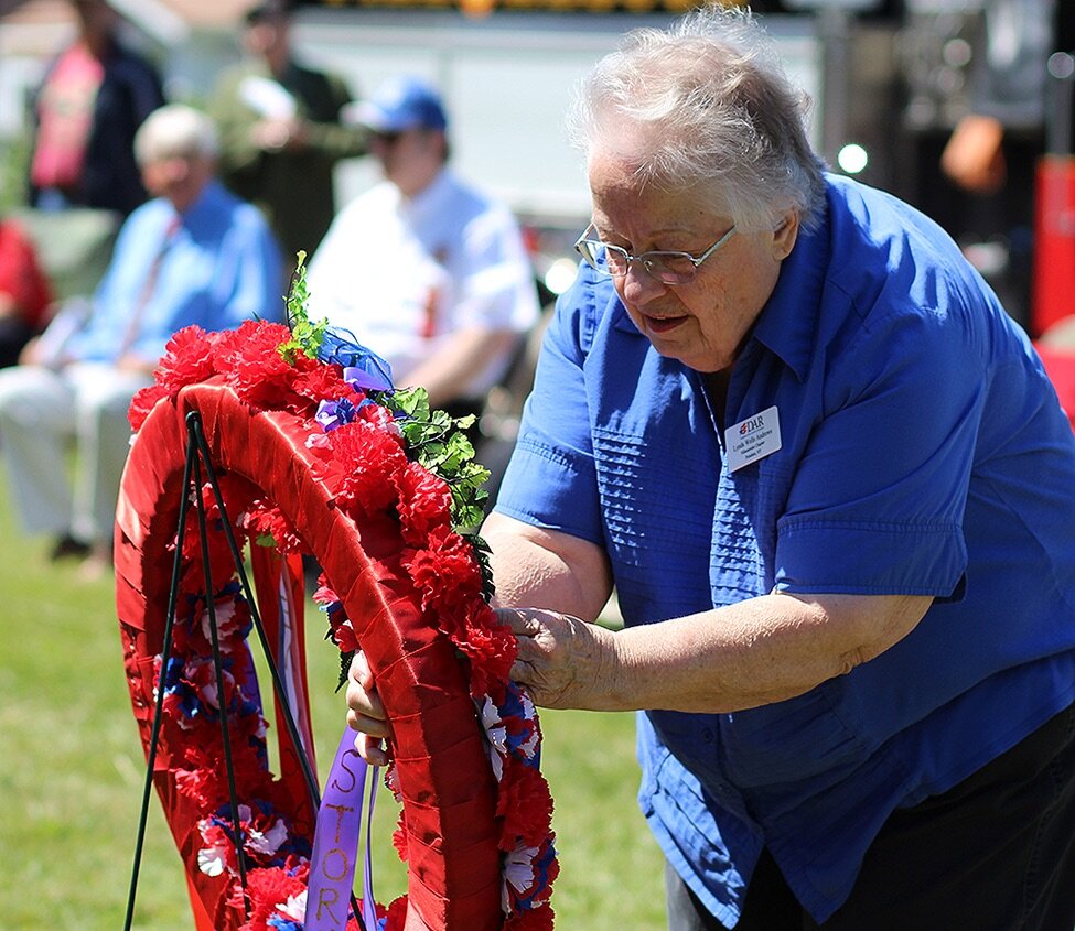    Lynda Andrews placing a ribbon on the ceremonial wreath on behalf of the Daughters of the American Revolution during the 2021 Gouverneur Memorial Day Observance. (Rachel Hunter photo)  
