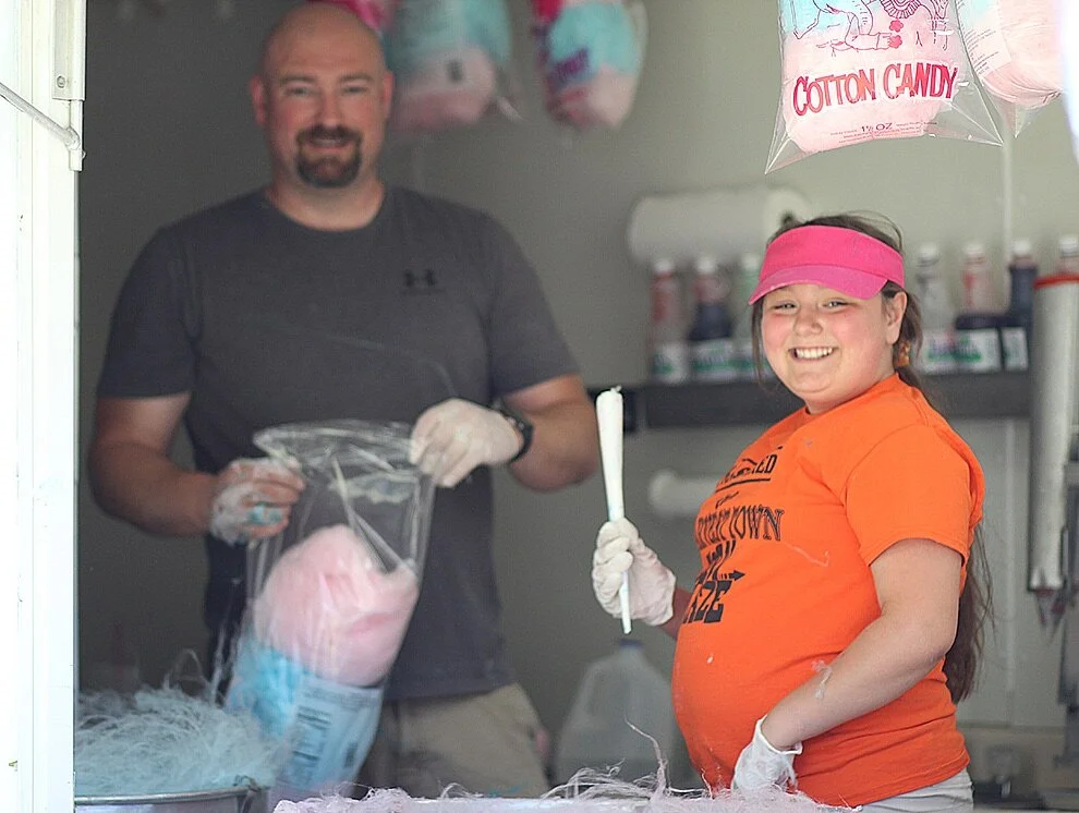    Audrey Ormasen of Gouverneur making cotton candy alongside her father, Nickolas Ormasen, in the Cotton Candy N More truck at the 30th Annual Arts In The Park on Saturday, June 19. (Rachel Hunter photo)  