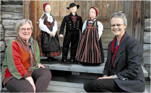 BUNADDOKKER: Grethe Rudi Bråten (t.v.) og Gunhild Nørsterud med tre dokker med bunader frå Valdres. Til venstre ein rutastakk, og i midten ein mannsbunad med stuttrøye. Til høgre dokka med bringedukbunad, laga av Berit Vidme, som ikkje hadde høve til å vera med på biletet.