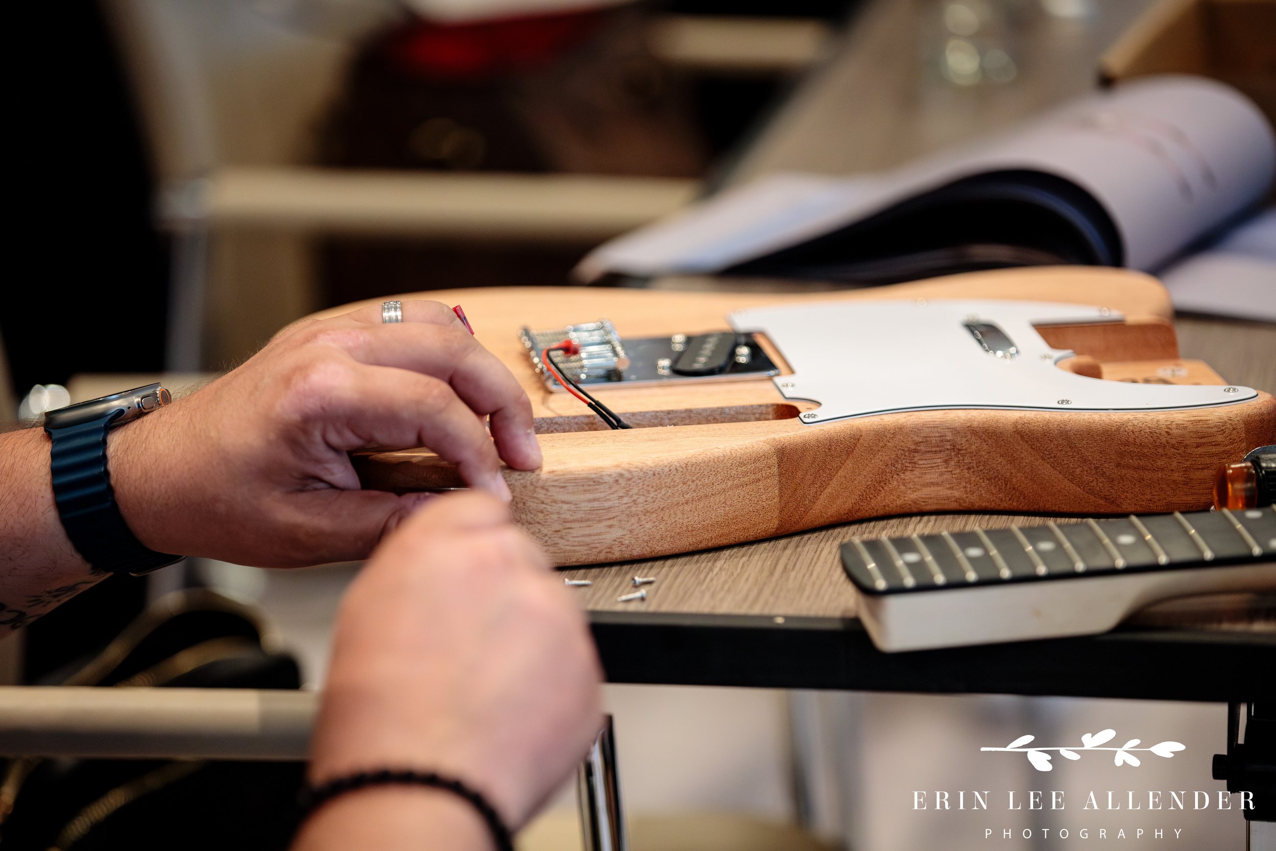 Nashville corporate event photography — close-up of team assembling a guitar during CBIZ Nashville Summit Guitars for Vets build