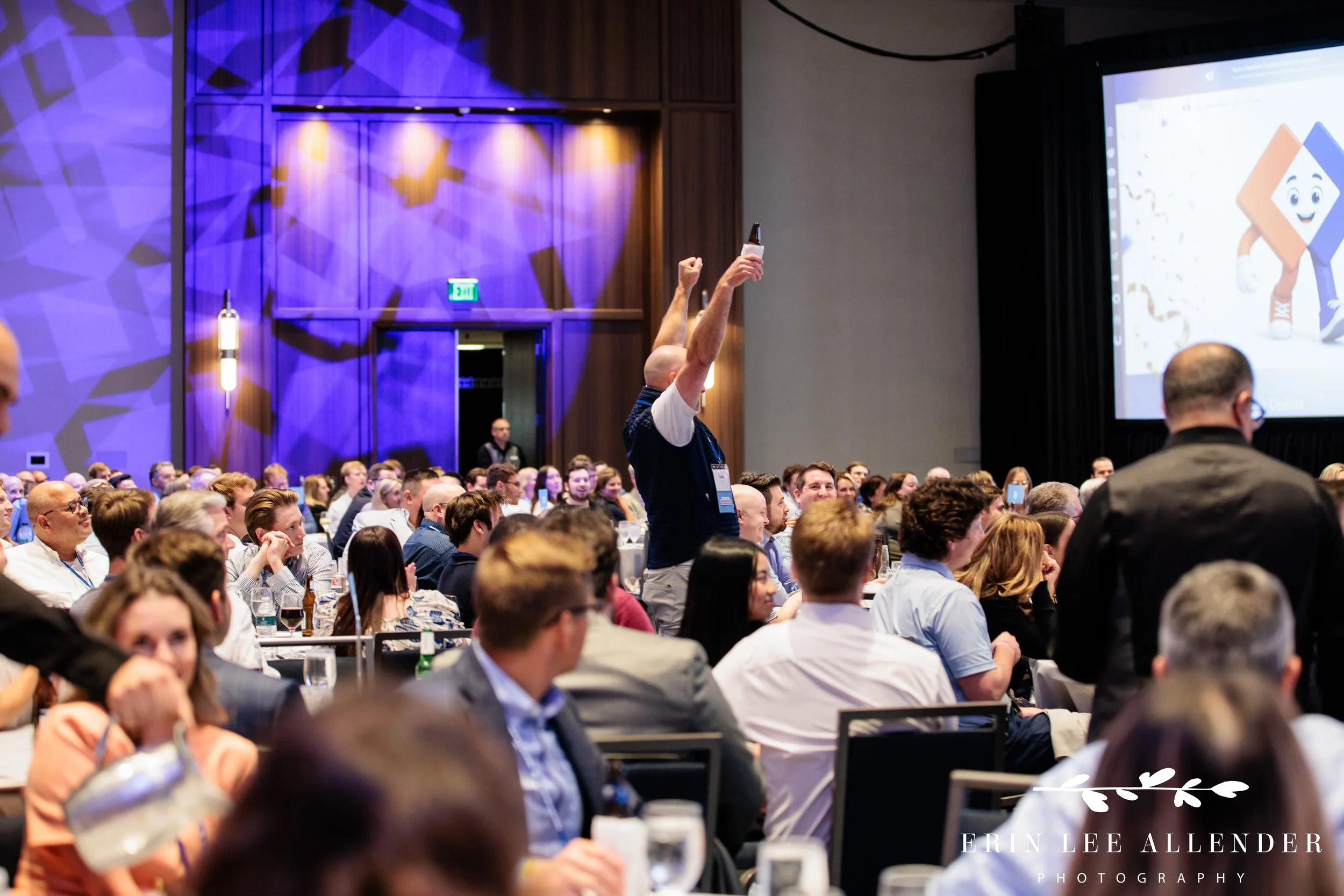 Nashville awards dinner photographer capturing a guest standing up and cheering from his seat during RubinBrown's awards ceremony at Opryland