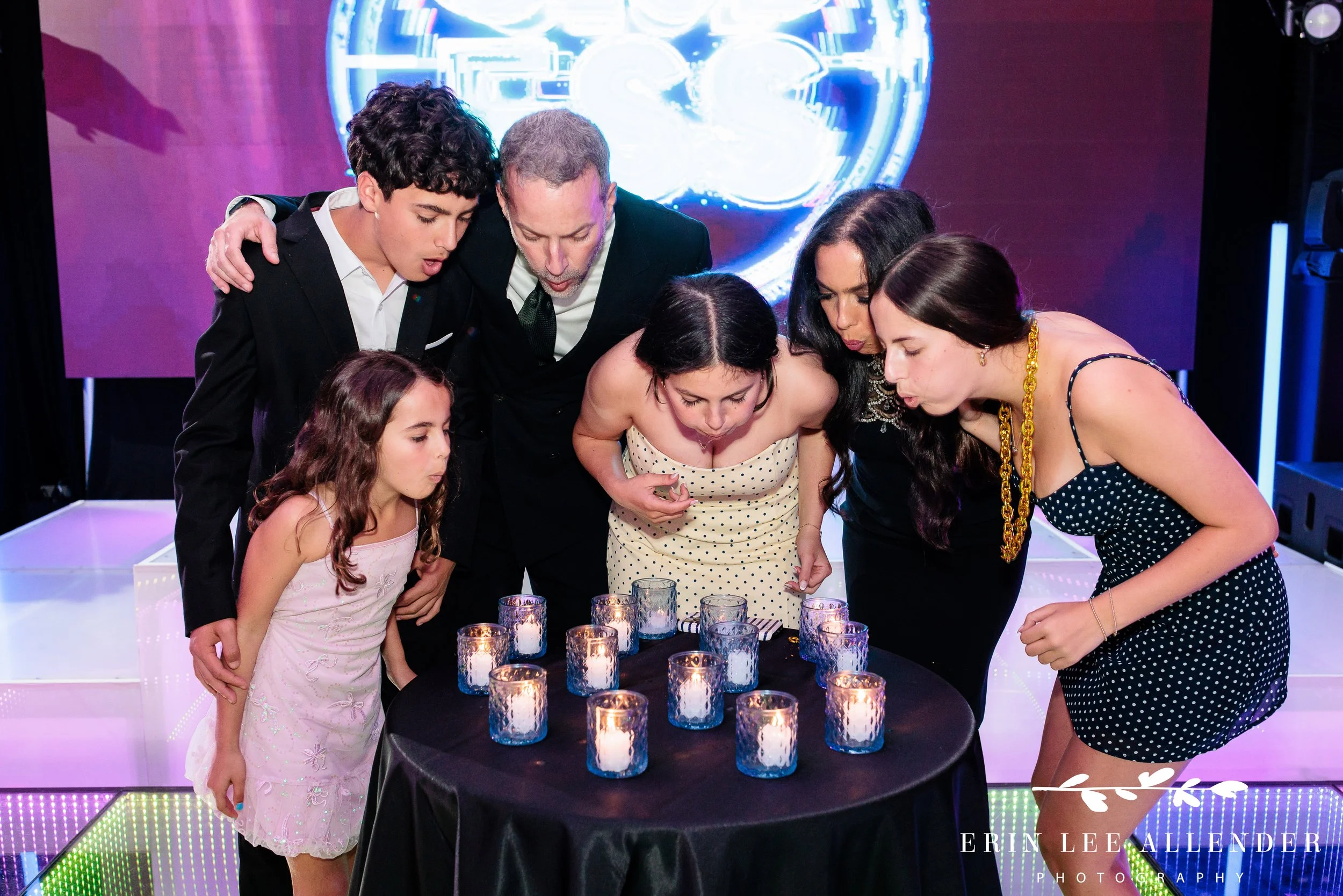Family blowing out candles during candle ceremony bat mitzvah