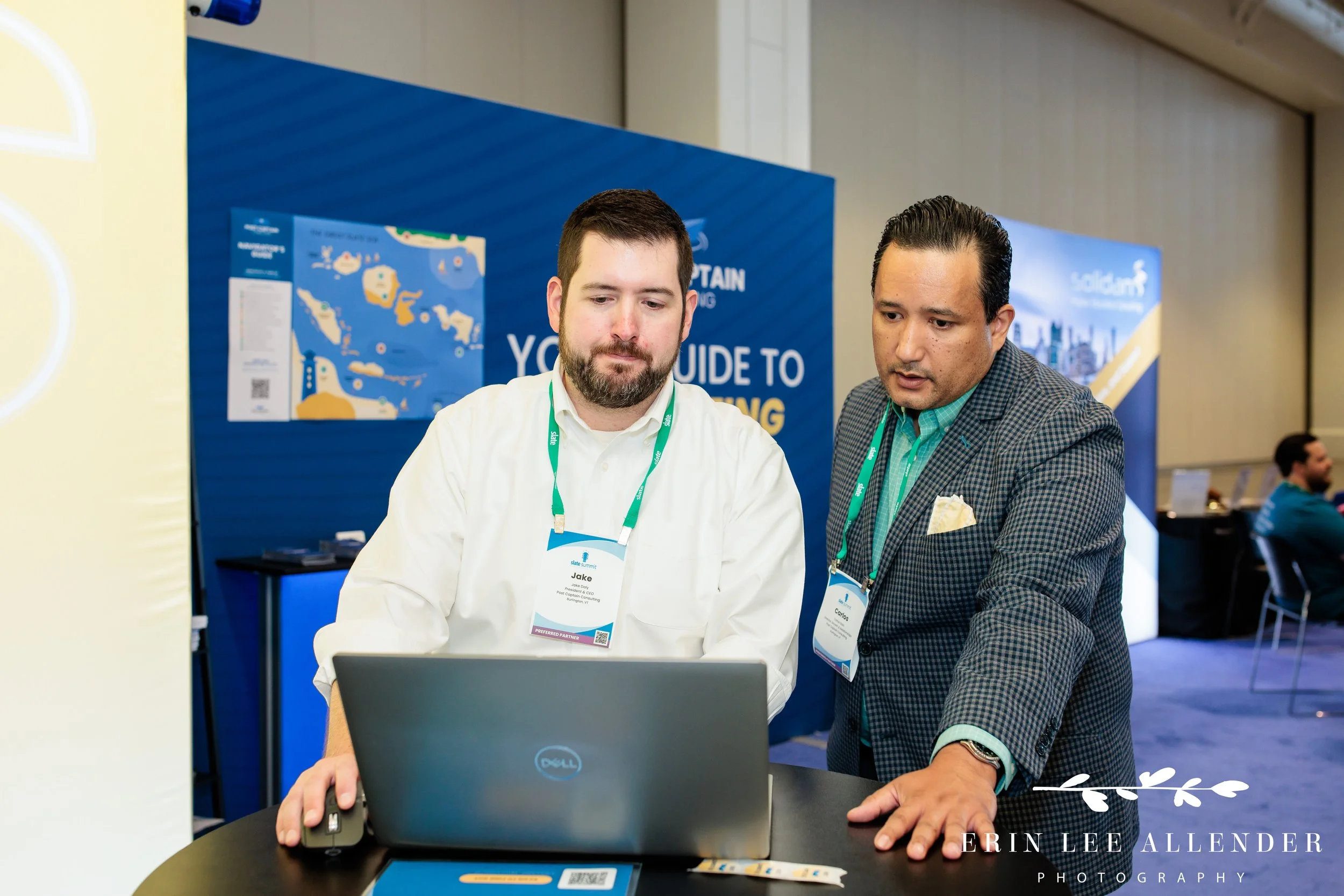 Nashville corporate event photography — Post Captain consultants reviewing something together on a laptop at the Slate Summit booth