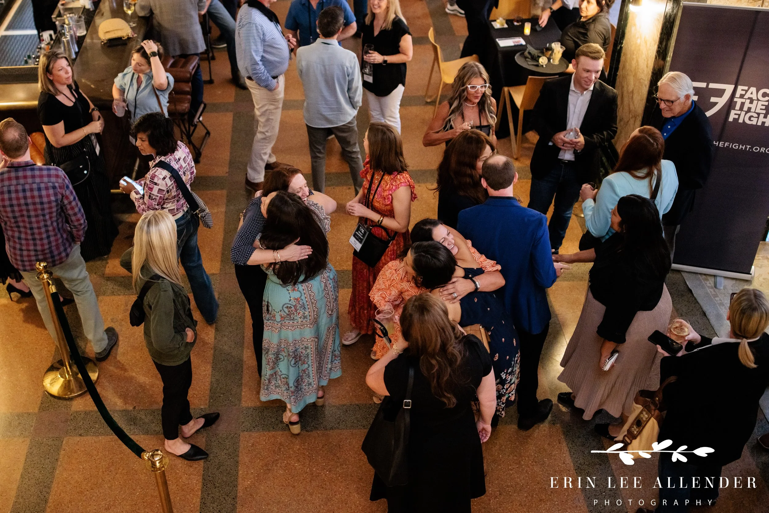 Nashville nonprofit event photography — overhead view of guests hugging during Face the Fight opening night at Noelle