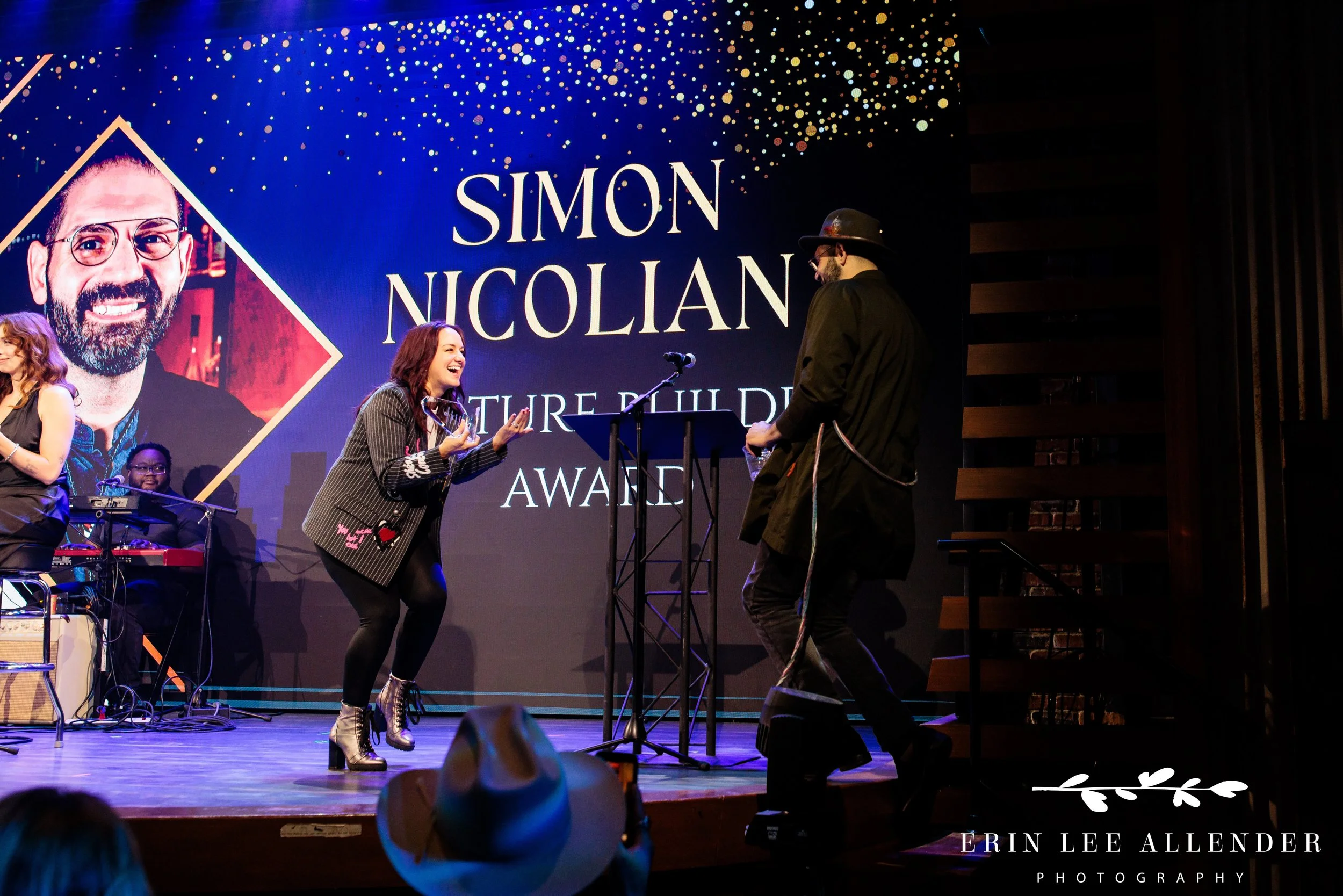Nashville gala photographer — award presenter cheering for advocacy award winner on stage, Woolworth Theatre Nashville