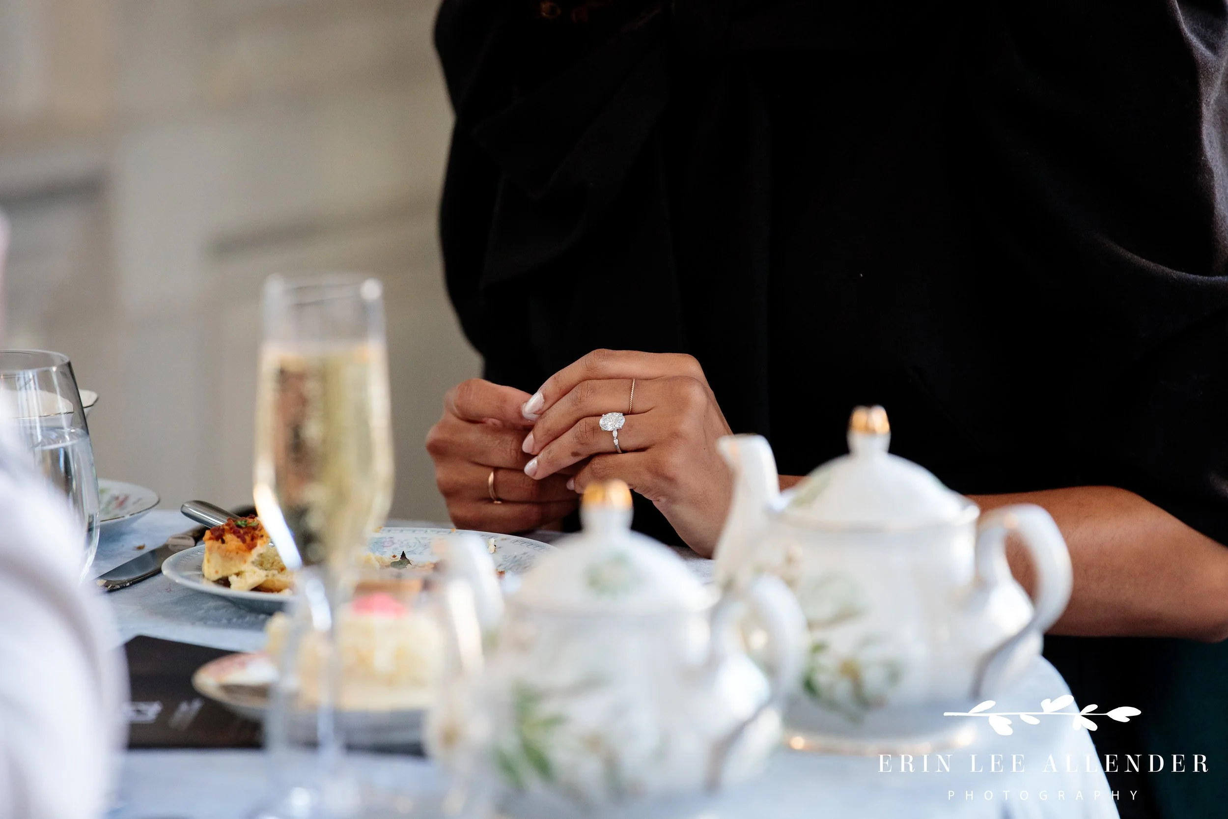 Fine china tea set and menu in focus with newly engaged couple softly blurred in the background, Nashville proposal photography at The Hermitage Hotel.