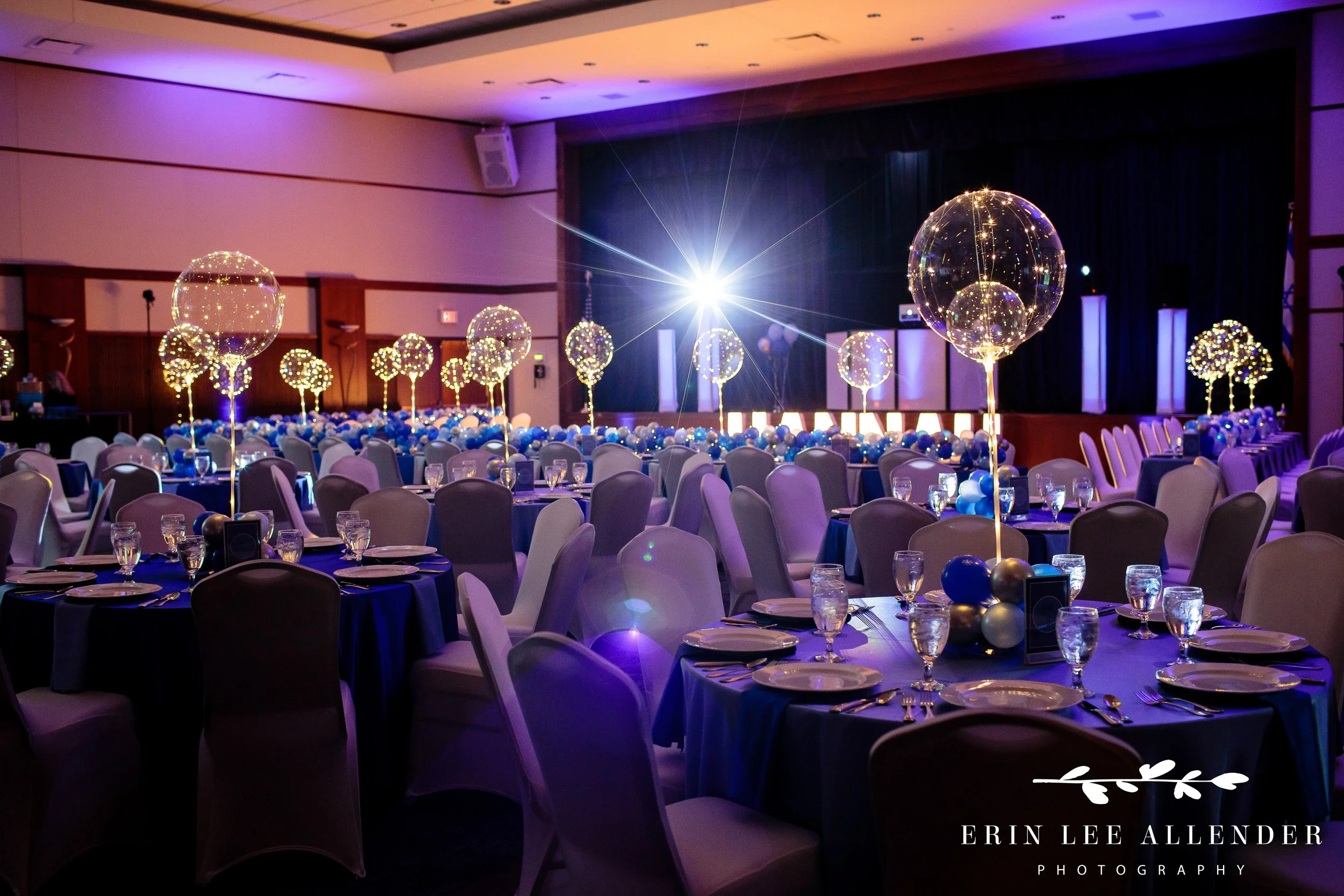 Moody wide-angle shot of the reception room filled with glowing balloons and decor.