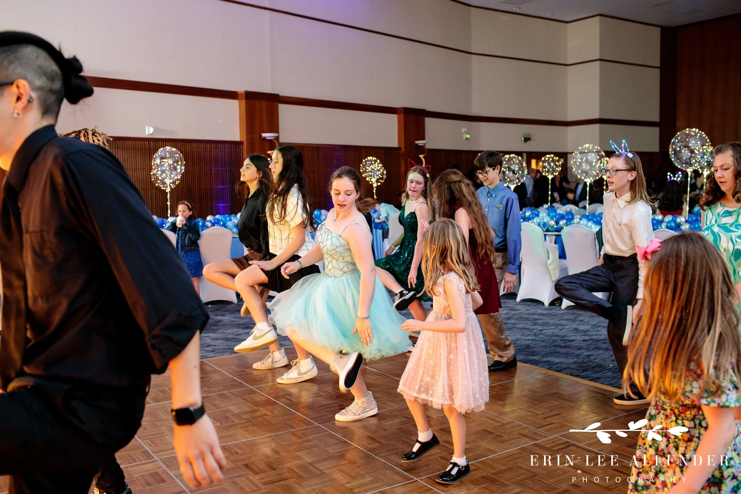 Hannah dancing at her Bat Mitzvah celebration surrounded by guests.