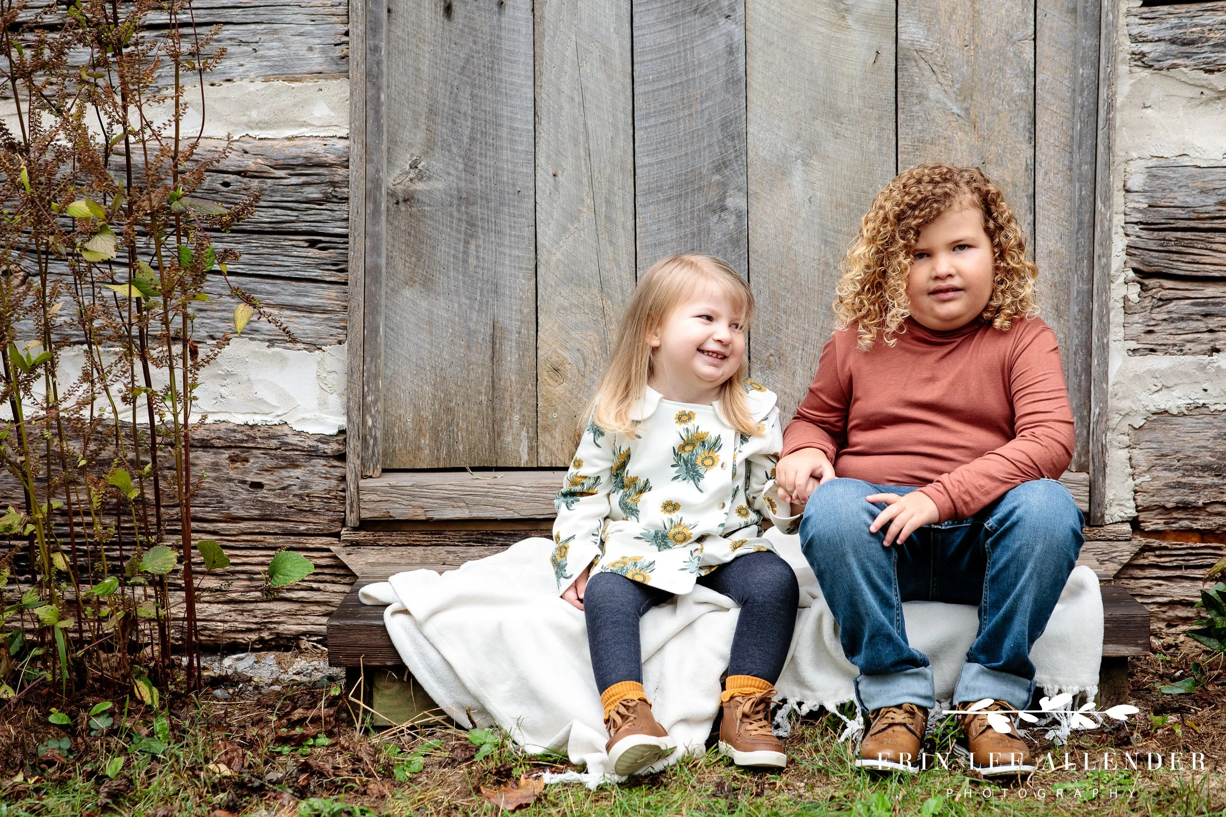 Brother and sister holding hands in front of historic cabin during Portland TN family photography.
