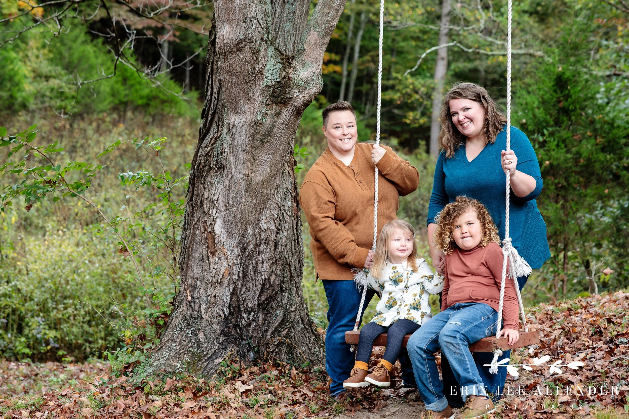 Two moms pushing children on rope swing during same sex family photography Nashville.