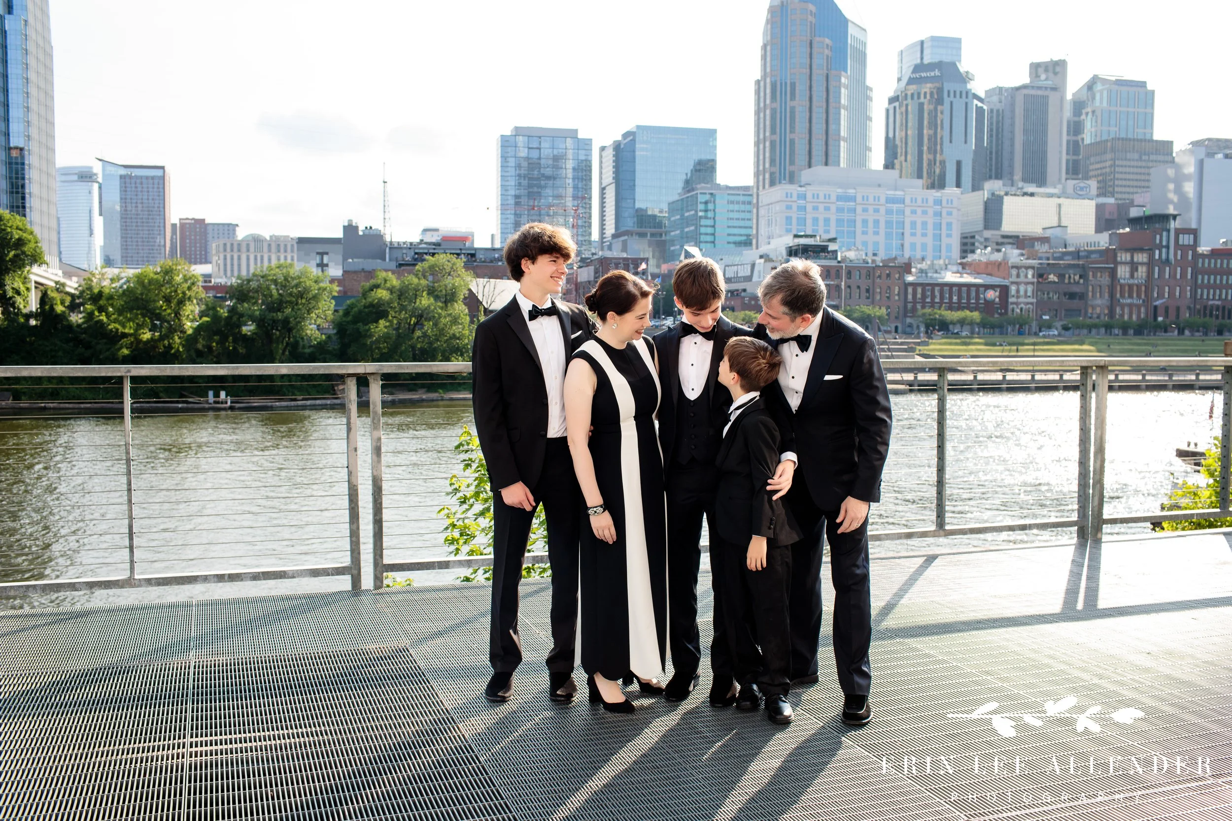 Family portrait in black tie with Nashville skyline backdrop at The Bridge Building.