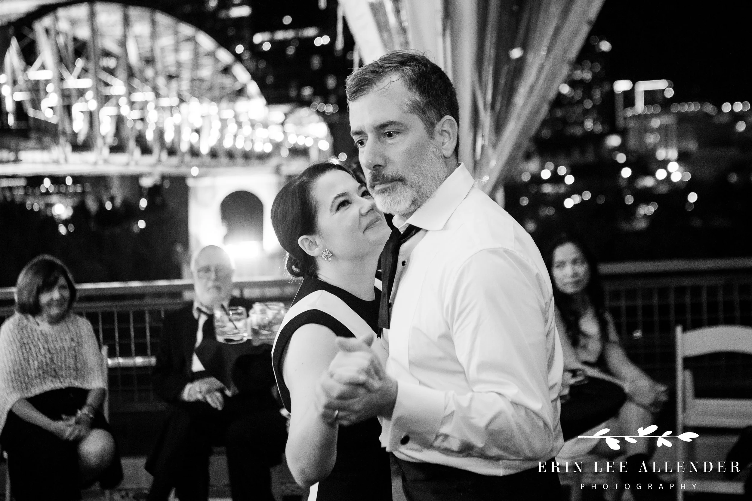 Parents dancing together with Nashville city lights in the background at The Bridge Building.