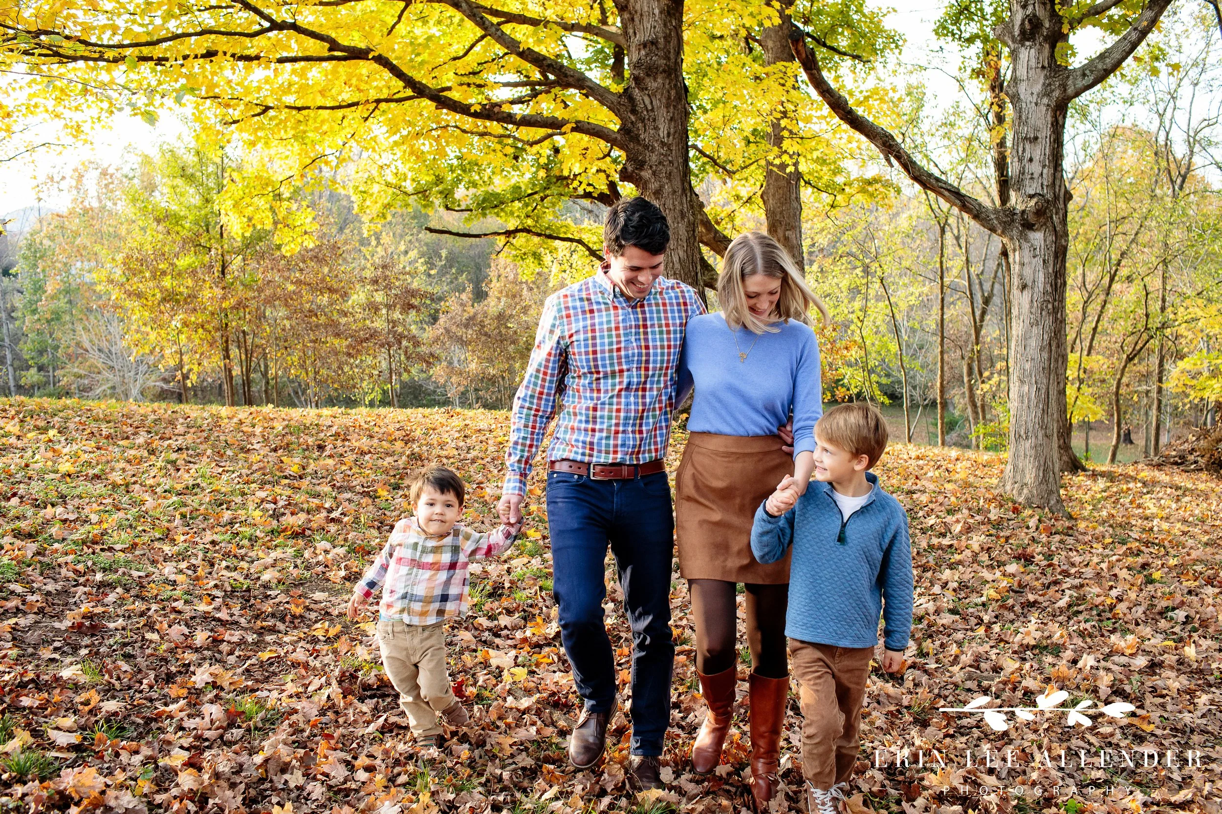 Family walking hand in hand through fall leaves at Ellington Agricultural Center, Nashville.