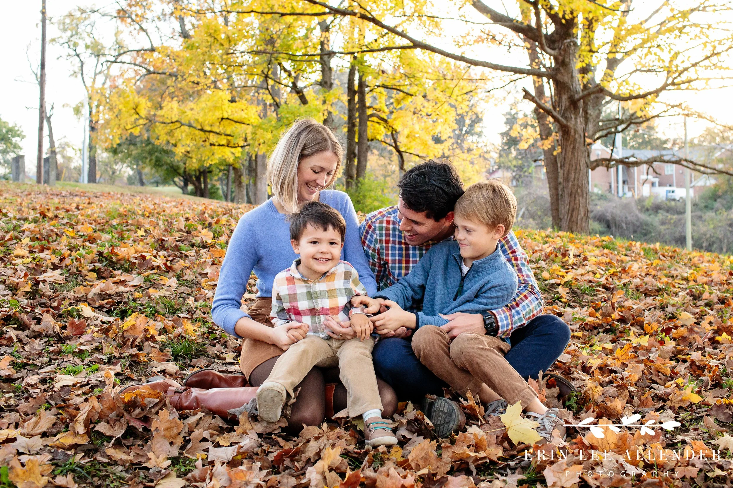 Family playing together in the leaves during a fall session at Ellington Agricultural Center in Nashville.