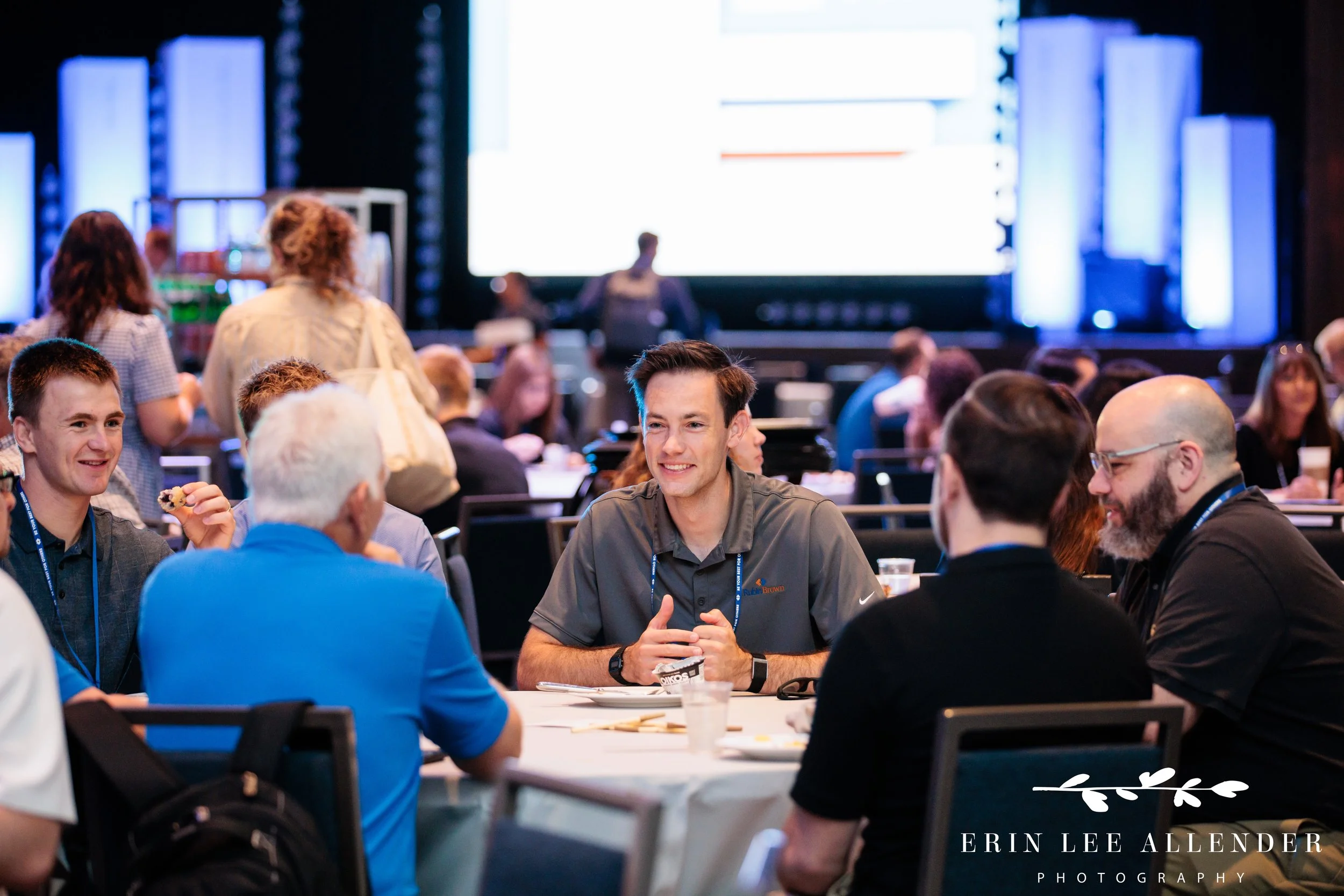 Nashville conference photographer capturing attendees in conversation with laptop screens in the background during RubinBrown's conference at Gaylord Opryland Resort