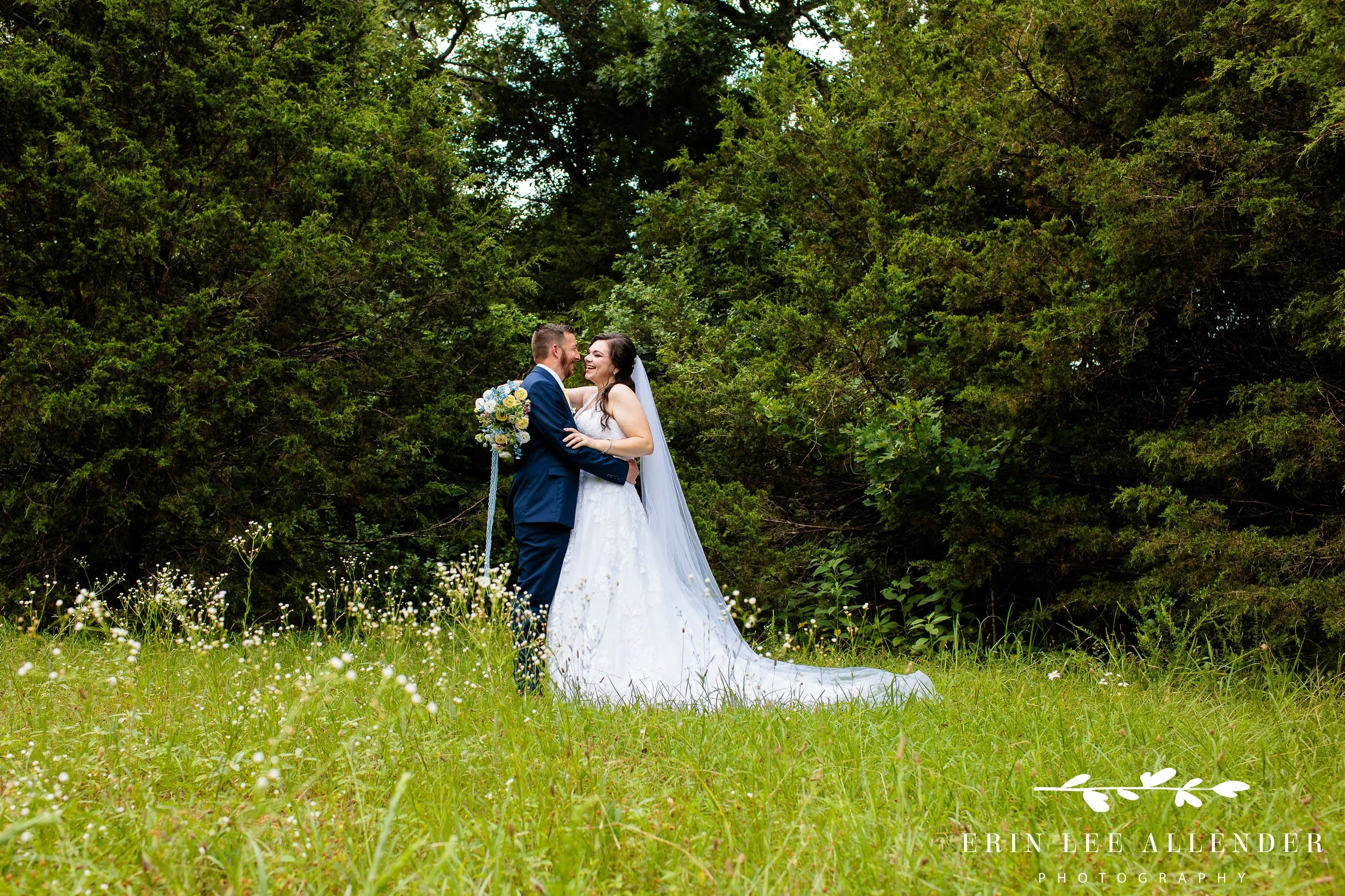 Bride and groom laughing together in a field at their Nashville wedding