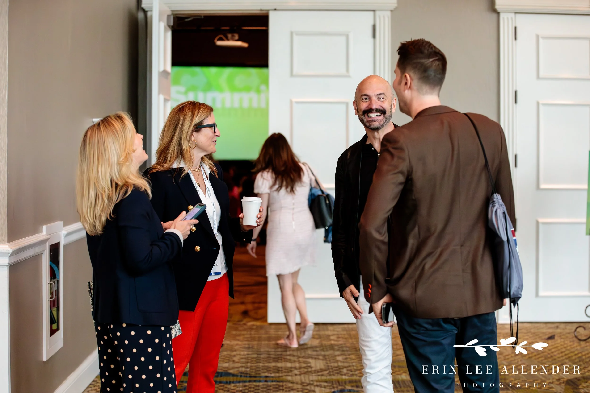 Attendees laughing and networking during corporate CX conference registration