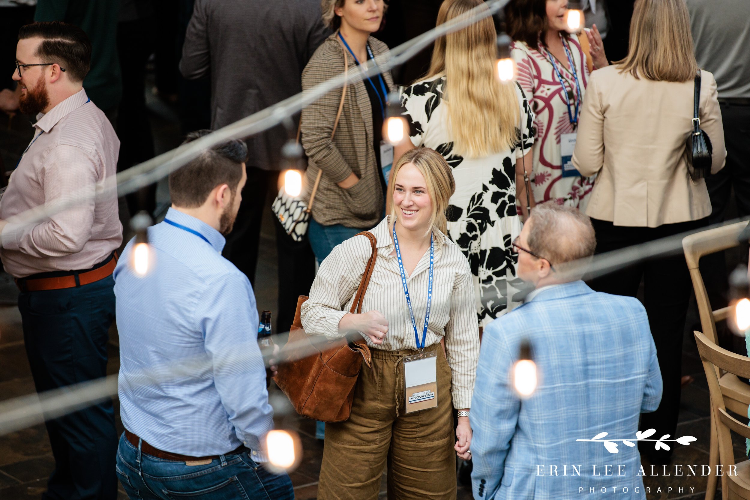 Nashville corporate event photographer capturing an overhead shot of guests talking through string lights on Delta Island at Gaylord Opryland Resort