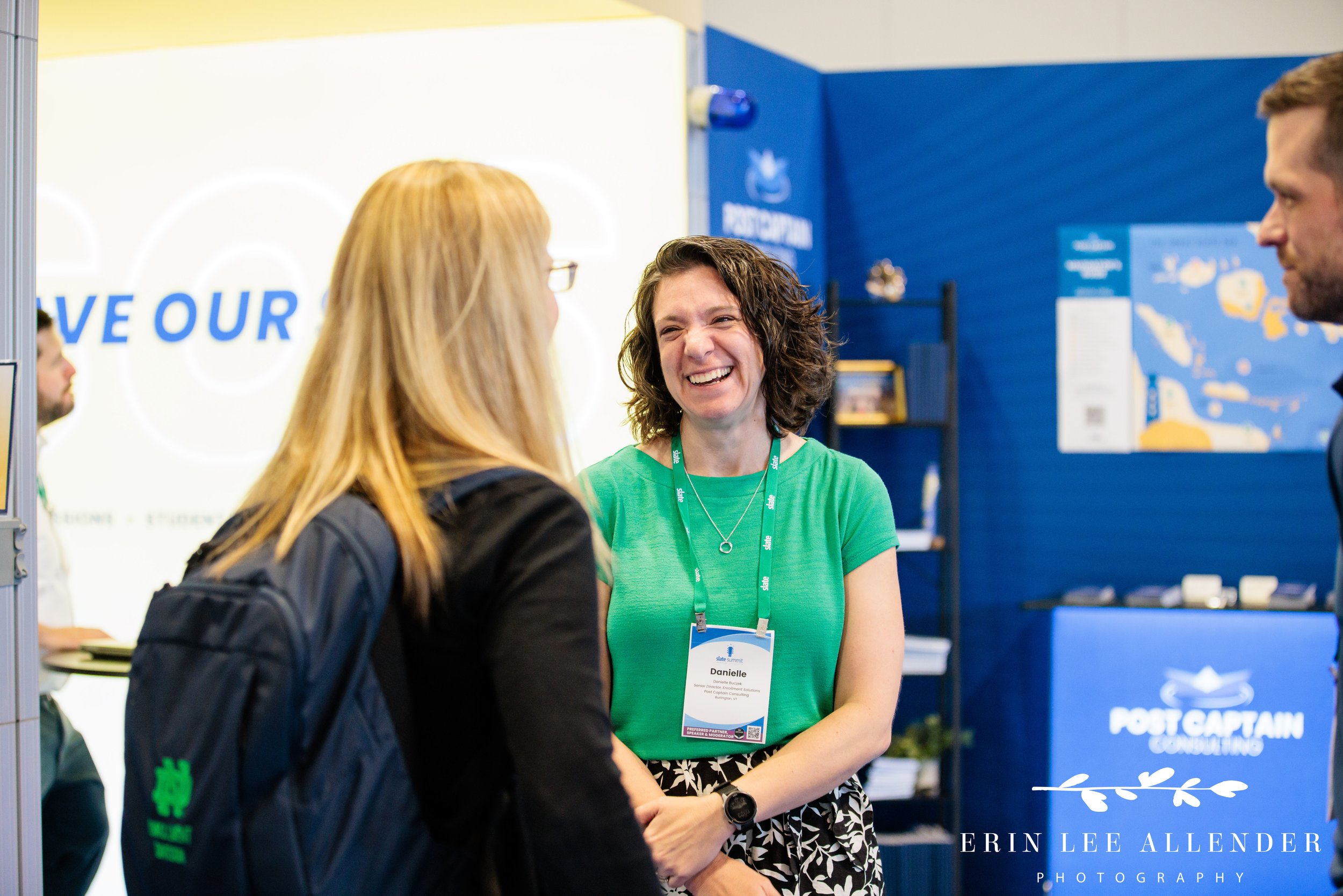 Nashville conference photography — Post Captain consultant laughing during a booth conversation at the Slate Summit, Music City Center