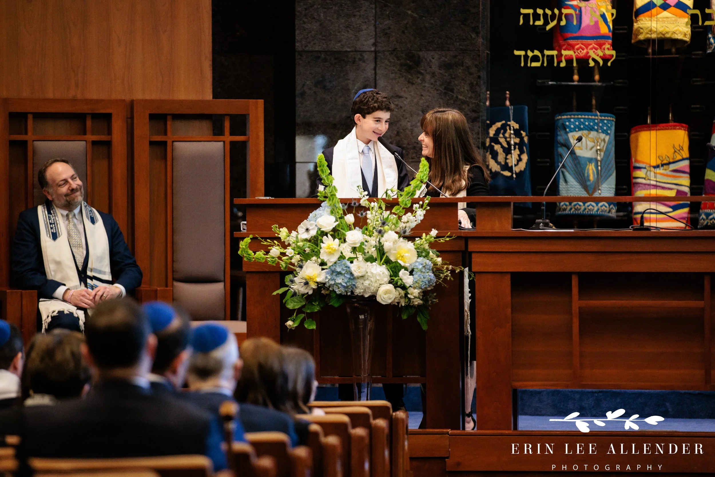 Rabbi and cantor smiling at bar mitzvah during Torah reading at The Temple