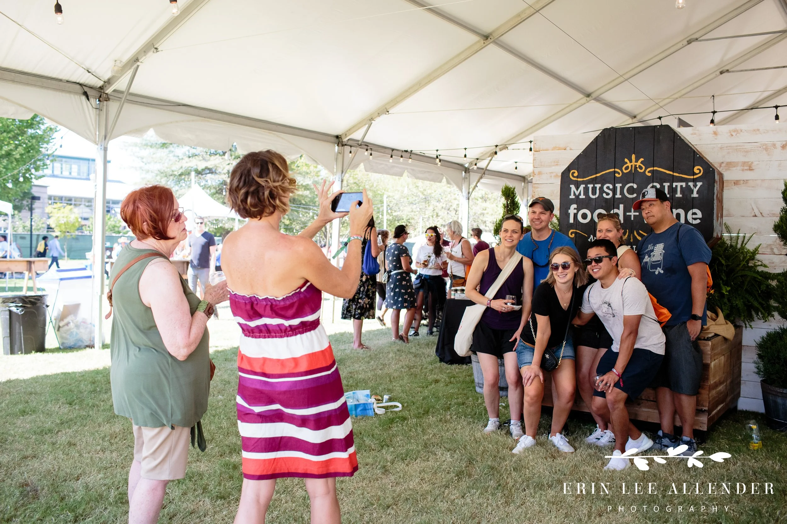 Festival guests taking a photo in front of the Music City Food and Wine Festival sign Nashville Tennessee