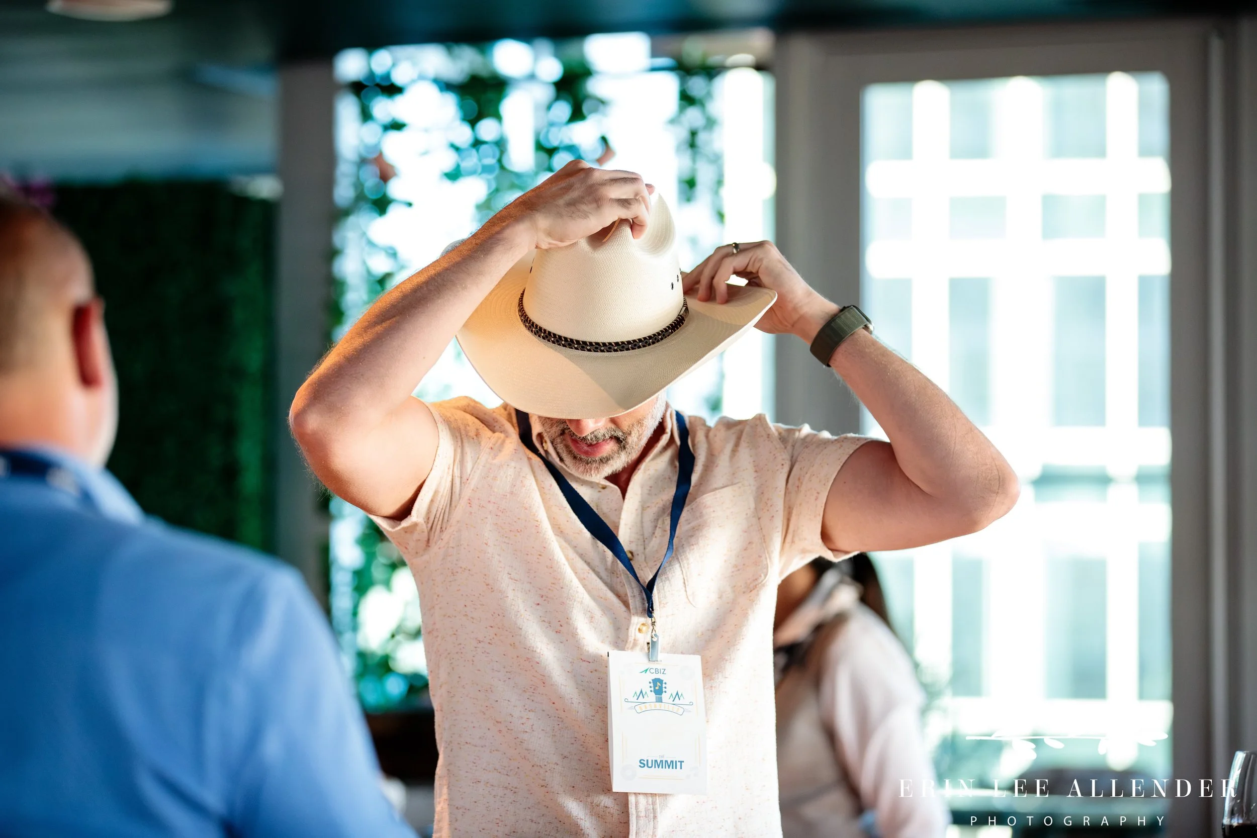 Nashville conference photographer — CBIZ Nashville Summit welcome reception guest putting on a cowboy hat at The Conrad