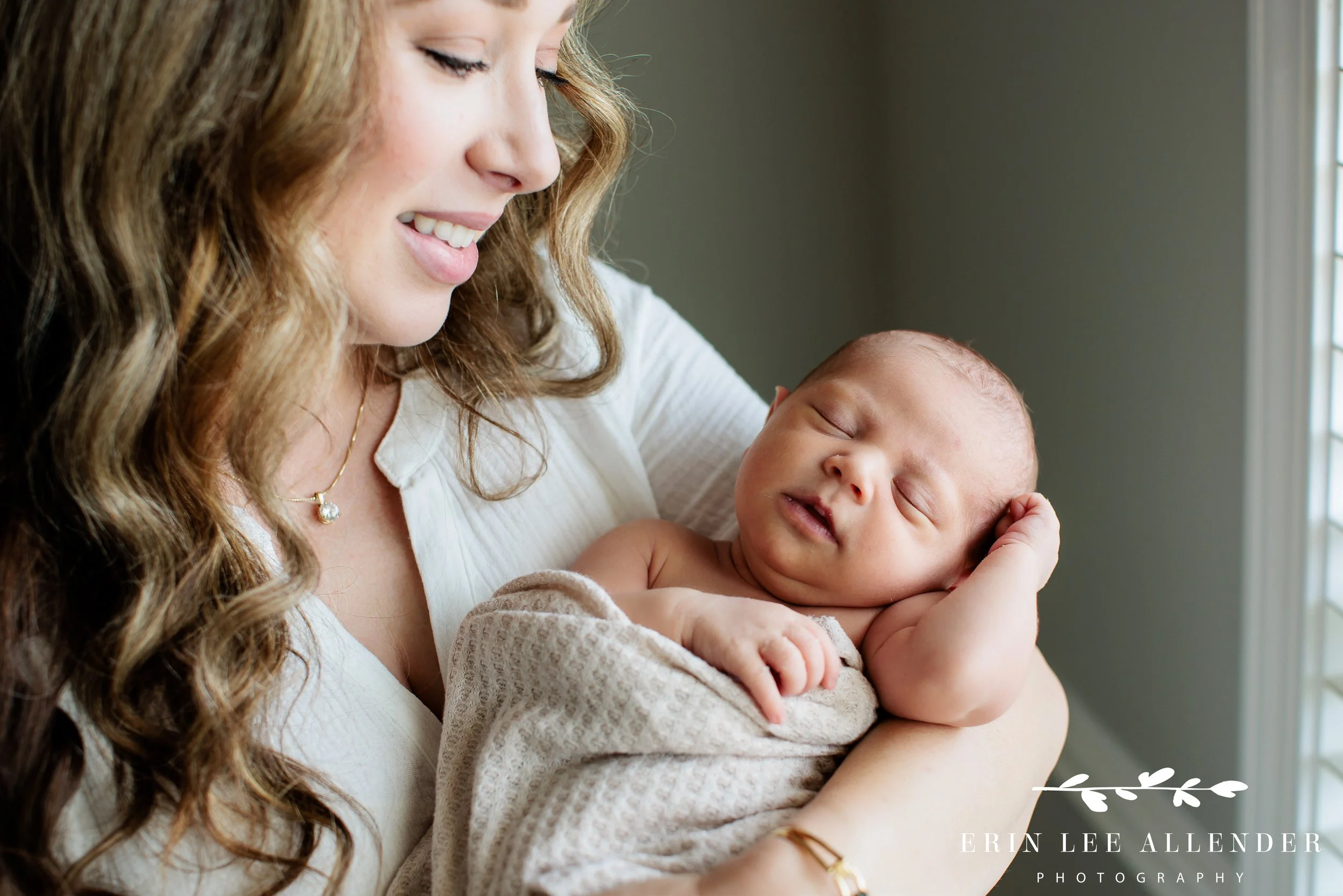 Nashville newborn photographer — mother holding swaddled baby girl during in-home newborn session