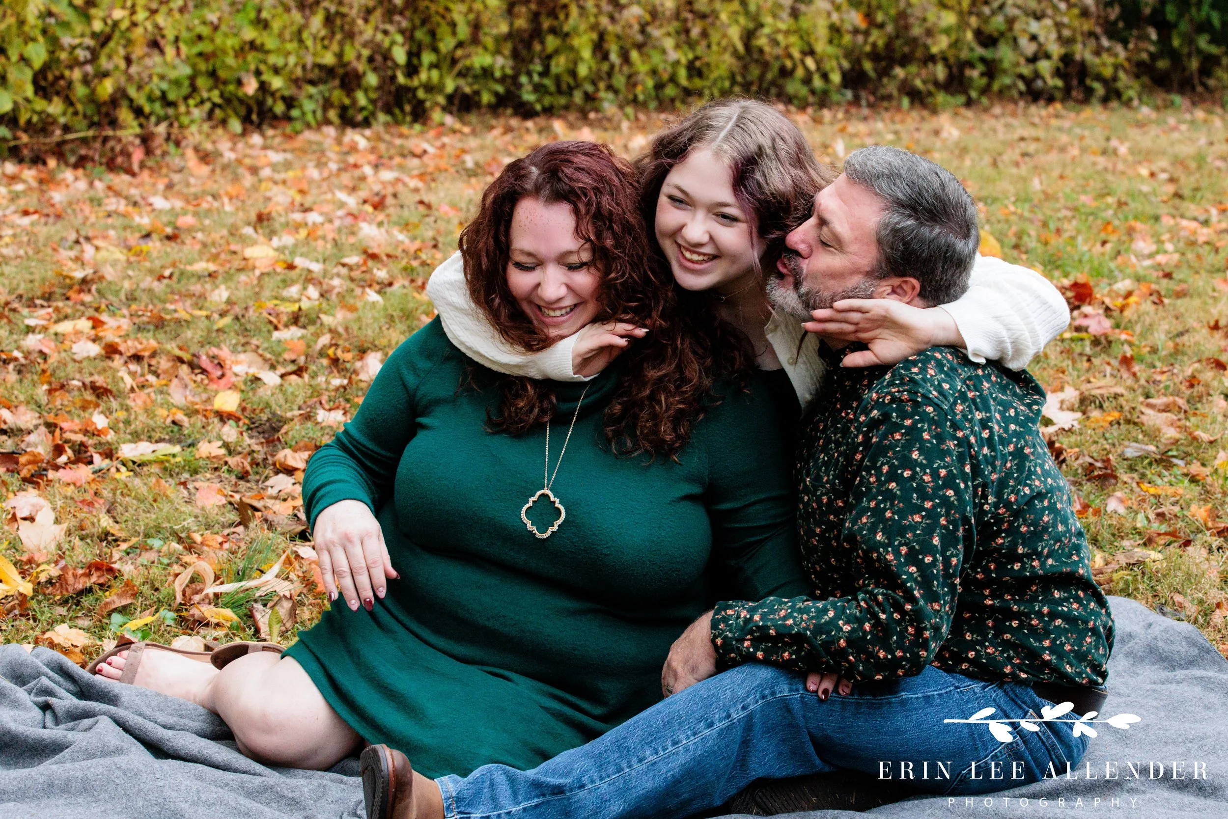 Daughter reaching around to hug her parents during a Nashville family portrait at Ellington Agricultural Center