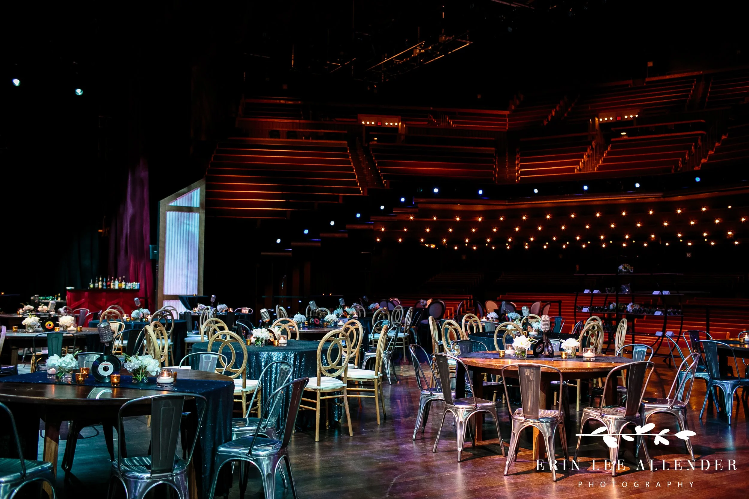 Nashville-inspired corporate dinner setup on Grand Ole Opry stage with hay bales and string lights