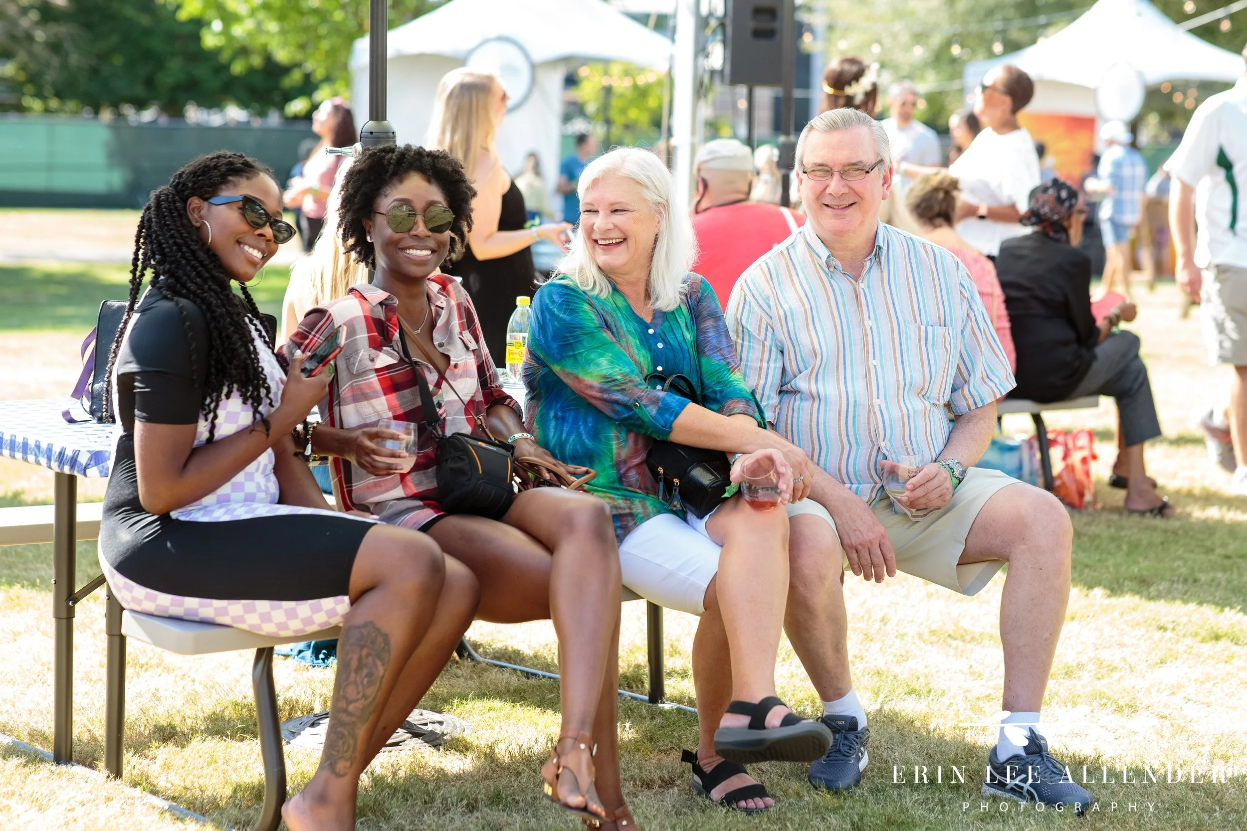 People sitting on a bench laughing with wine glasses at the Music City Food and Wine Festival Nashville Tennessee