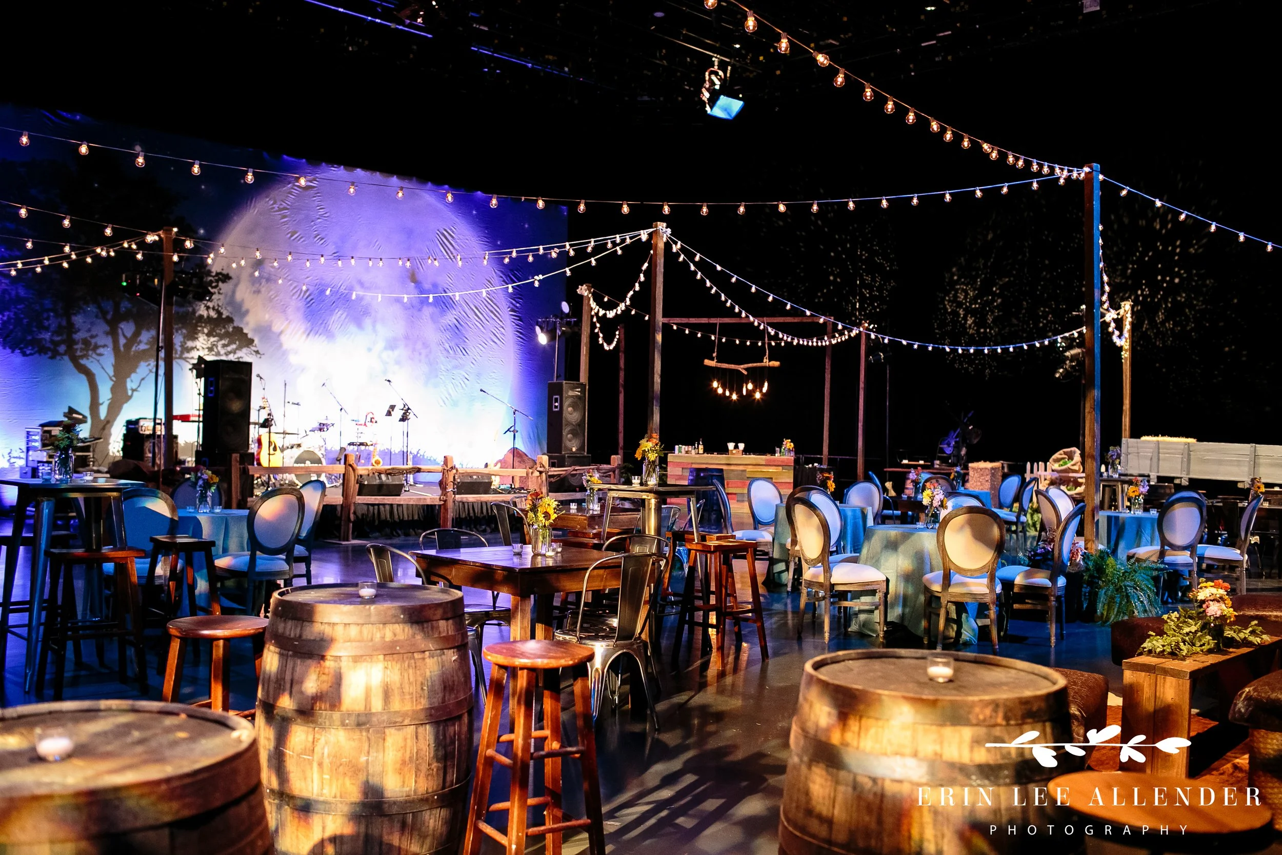 Decorated tables and café lights on Grand Ole Opry stage for corporate dinner Nashville
