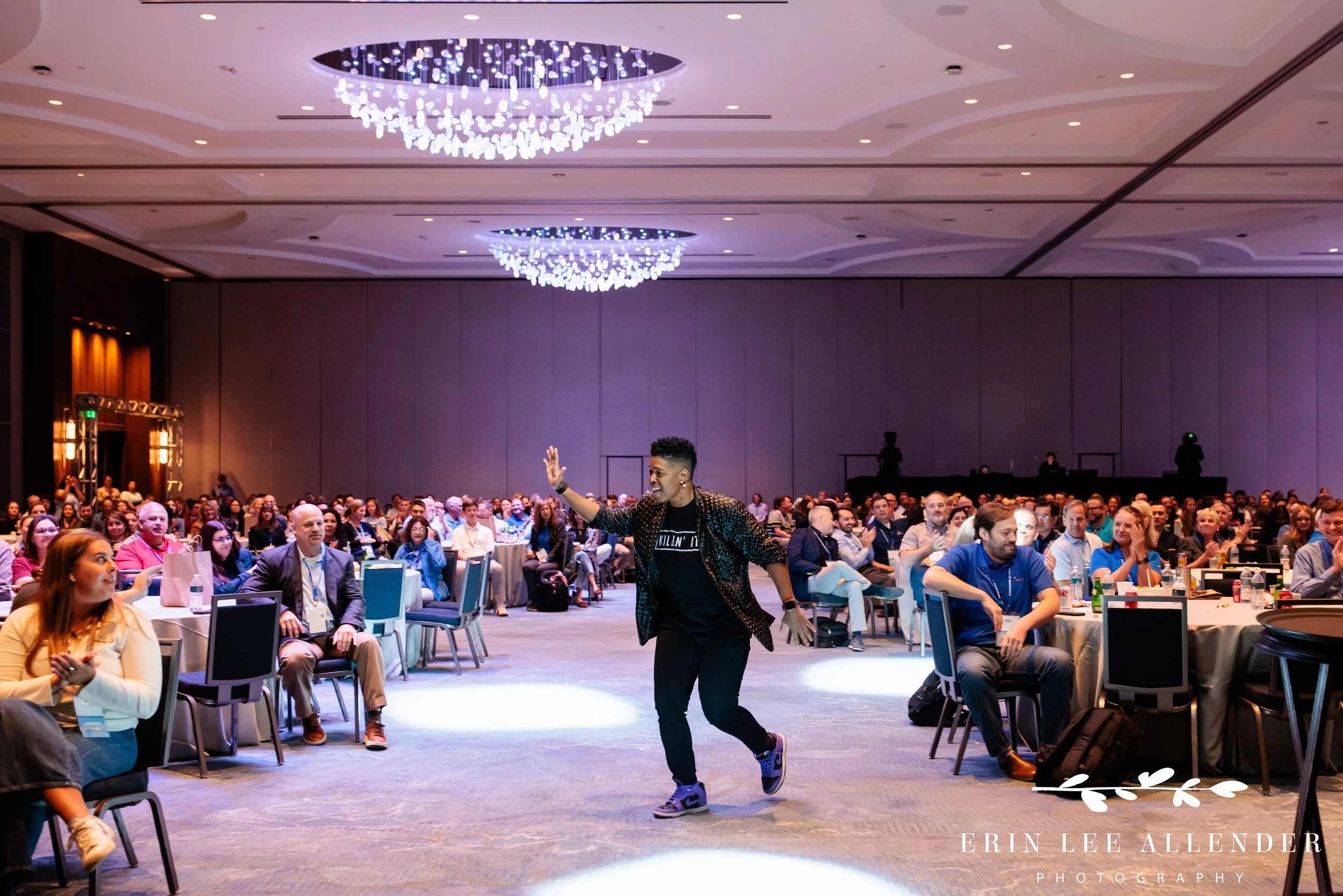 Opryland Hotel conference photography of Vernice Armour coming down the aisle high-fiving attendees during her keynote at RubinBrown's conference