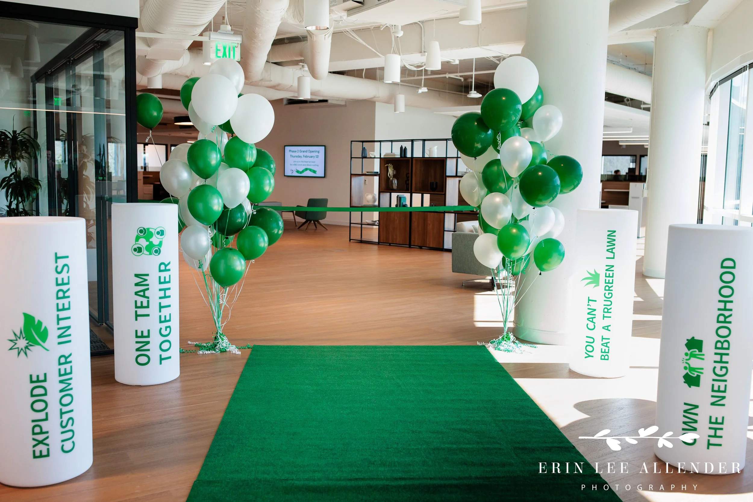 Nashville corporate event photography — green and white balloons with turf carpet setup before TruGreen ribbon cutting ceremony