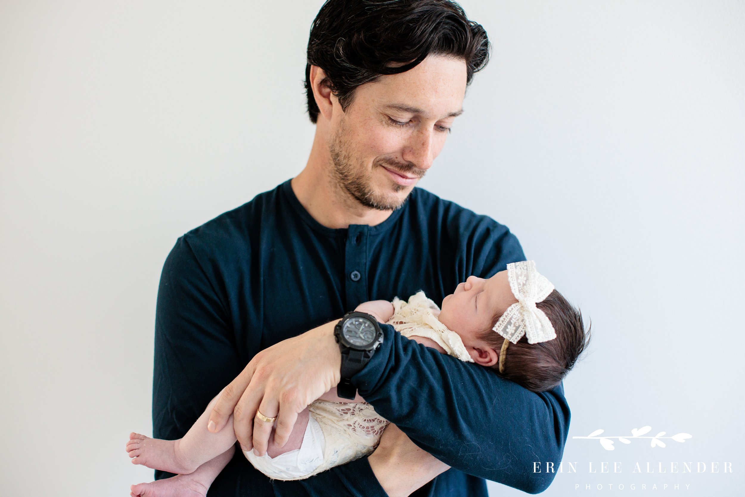 Dad holding newborn baby girl during a Nashville in-home newborn session