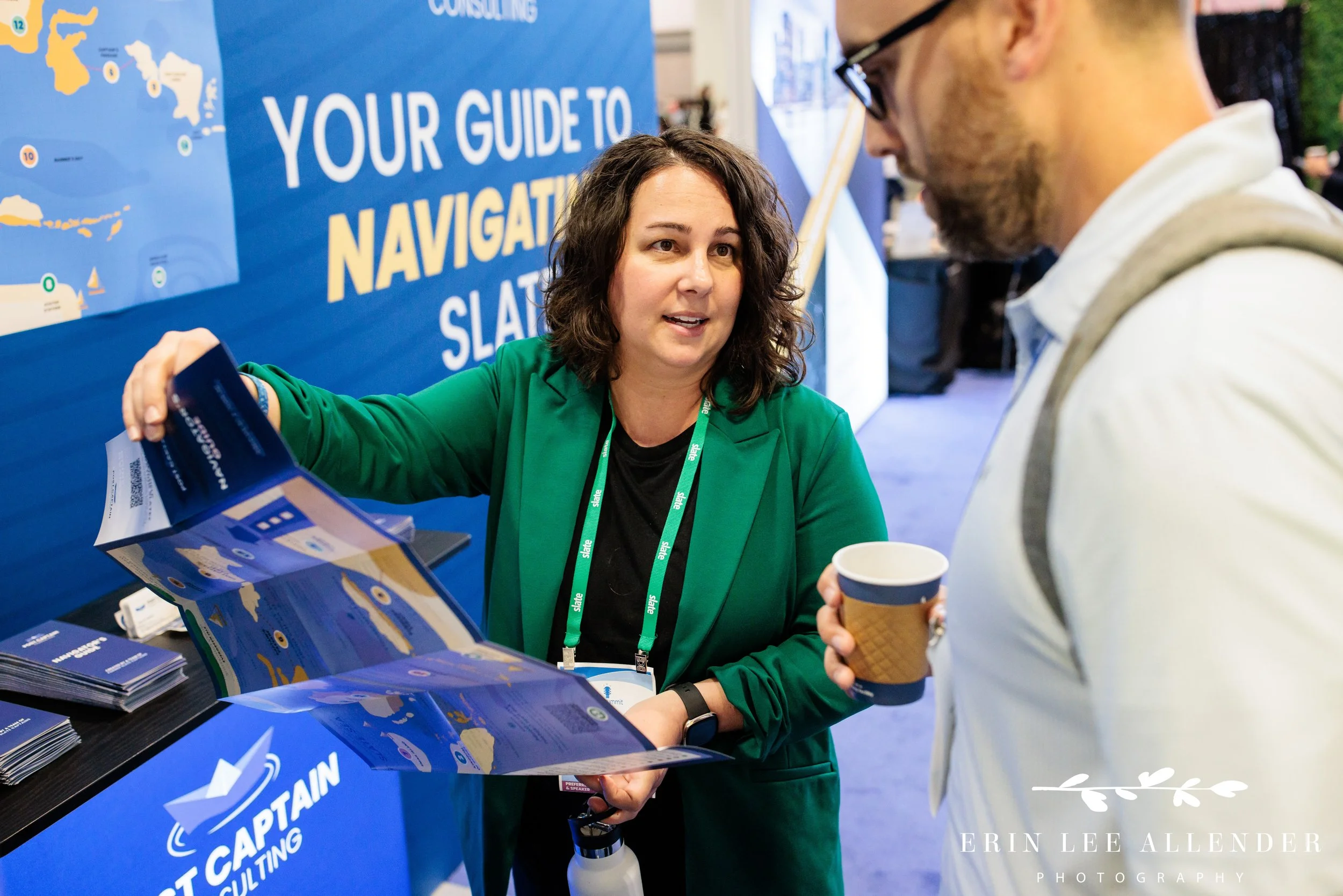 Nashville conference photographer — Post Captain consultant holding up their Slate cheat-sheet map giveaway at the Slate Summit booth