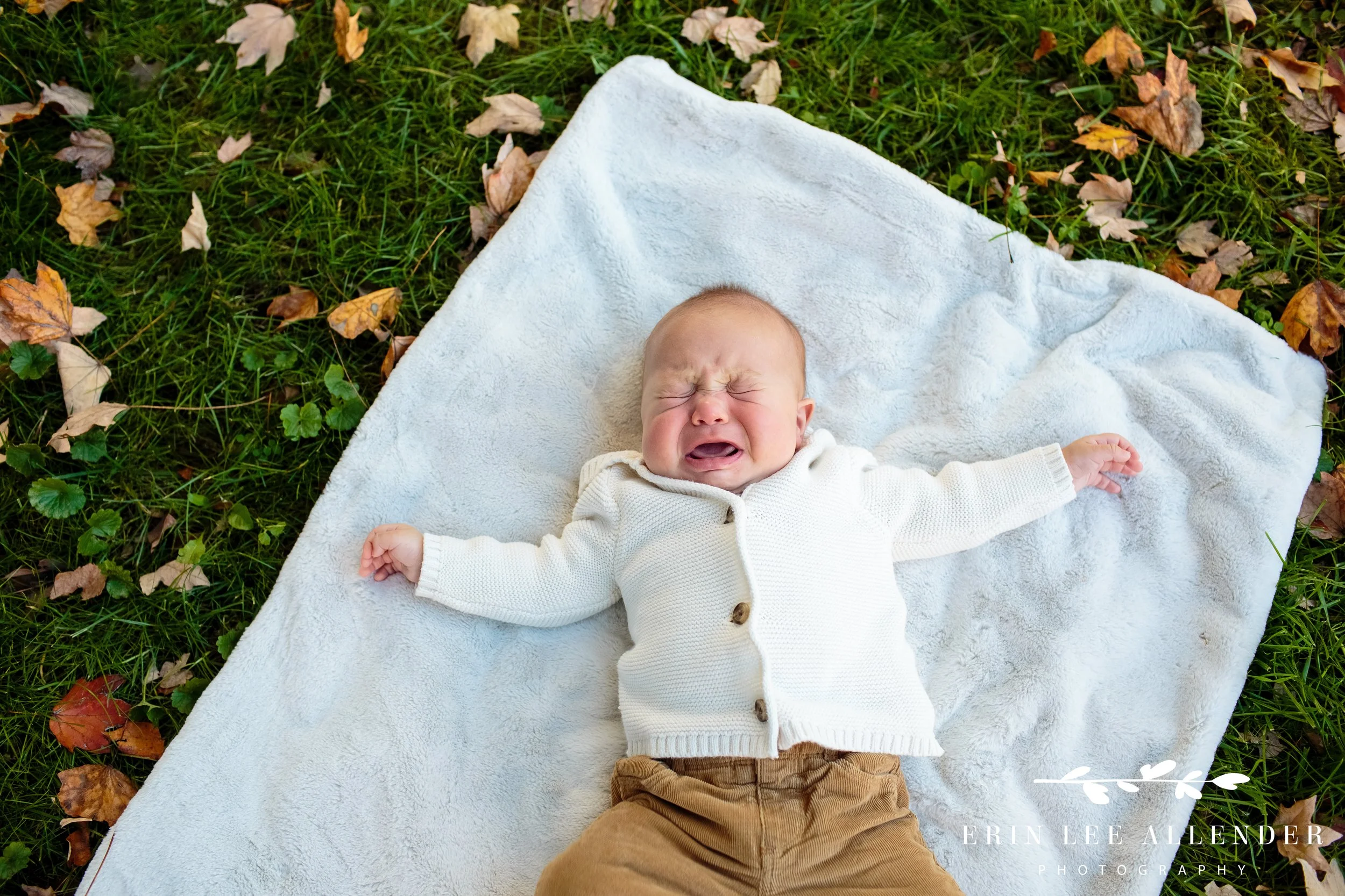 Baby letting out a few tears while being held by parents during a Vanderbilt family session.