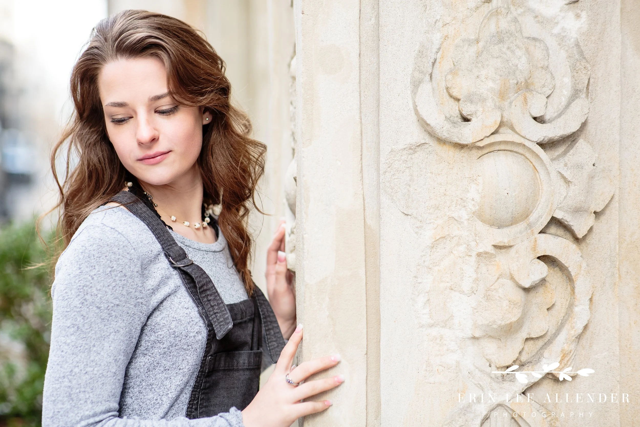 Nashville senior portrait — senior leaning into a historic limestone arch doorway in downtown Nashville, natural light, classic portrait photography
