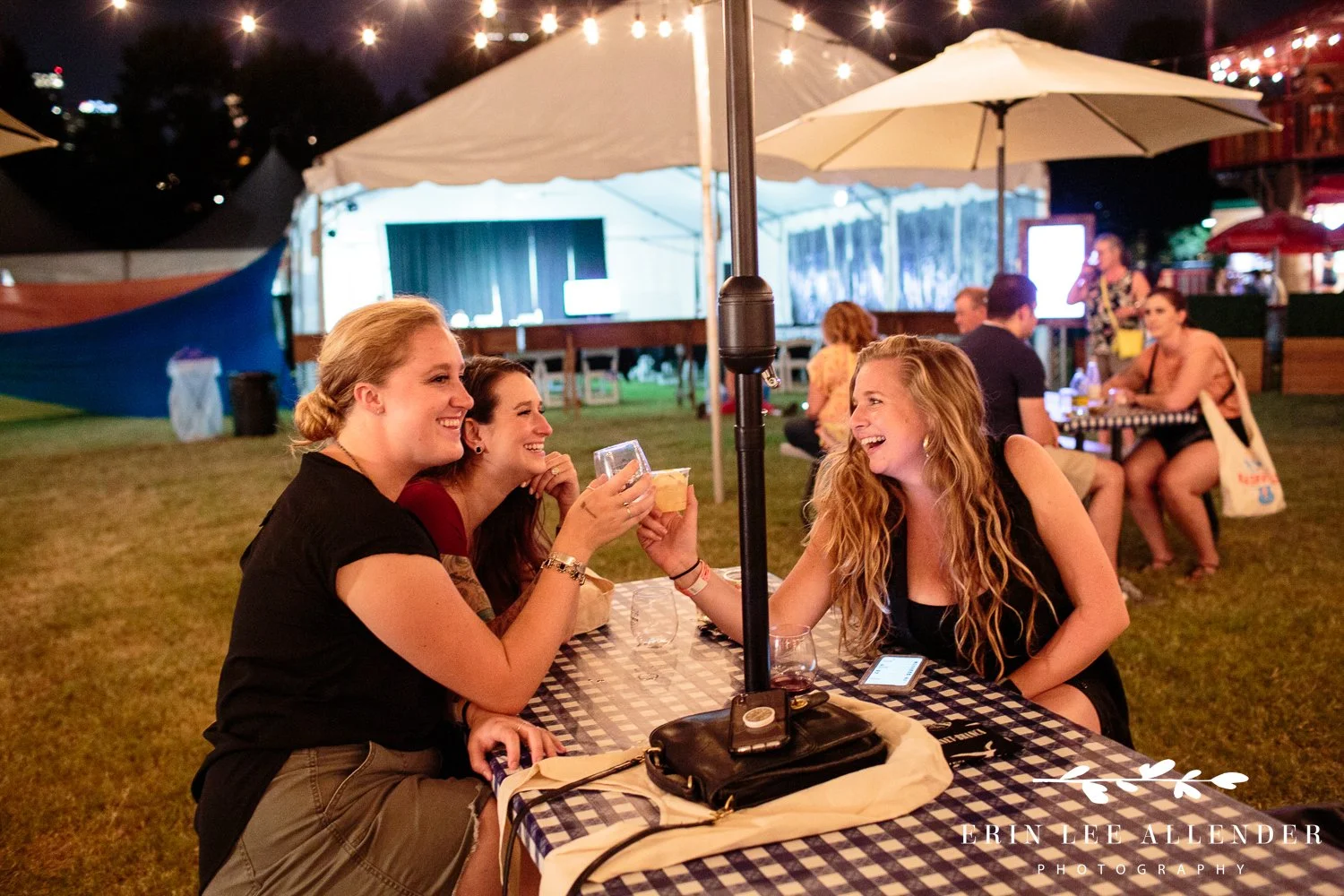 Women cheers drinks at a picnic table at the Music City Food and Wine Festival Nashville Tennessee